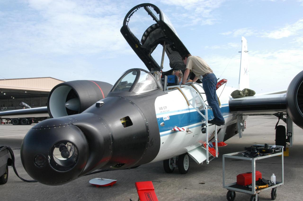 KENNEDY SPACE CENTER, FLA. -   At Patrick Air Force Base in Cocoa Beach, Fla., workers prepare the WB-57F aircraft that will take photos of Space Shuttle Discovery during its launch on Return to Flight mission STS-114.   NASA approved the development and implementation of the aircraft-based imaging system, known as the WB-57 Ascent Video Experiment (WAVE).  The WAVE provides both ascent and entry imagery and enables better observation of the Shuttle on days of heavier cloud cover and areas obscured from ground cameras by the launch exhaust plume. WAVE comprises a 32-inch-ball turret system mounted on the nose of two WB-57 aircraft. The turret houses an optical bench, providing installation of both HDTV and infrared cameras. Optics consist of an 11-inch-diameter, 4.2 meter fixed-focal-length lens. The system can be operated in both auto track and manual modes.