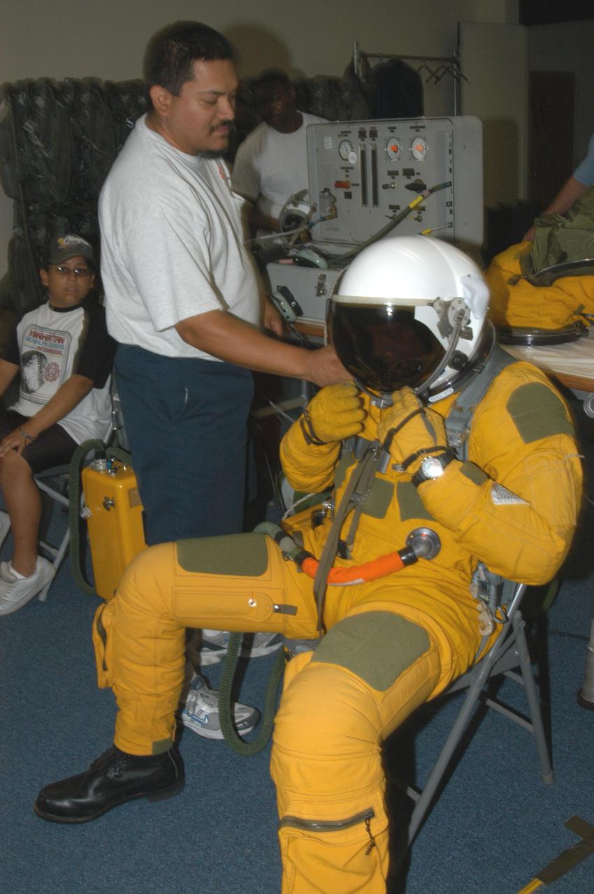 KENNEDY SPACE CENTER, FLA. -  NASA pilot Rick Hull secures his helmet before a test flight of the WB-57F aircraft that will take photos of Space Shuttle Discovery during its launch on Return to Flight mission STS-114.  NASA approved the development and implementation of the aircraft-based imaging system, known as the WB-57 Ascent Video Experiment (WAVE).  The WAVE provides both ascent and entry imagery and enables better observation of the Shuttle on days of heavier cloud cover and areas obscured from ground cameras by the launch exhaust plume. WAVE comprises a 32-inch-ball turret system mounted on the nose of two WB-57 aircraft. The turret houses an optical bench, providing installation of both HDTV and infrared cameras. Optics consist of an 11-inch-diameter, 4.2 meter fixed-focal-length lens. The system can be operated in both auto track and manual modes.