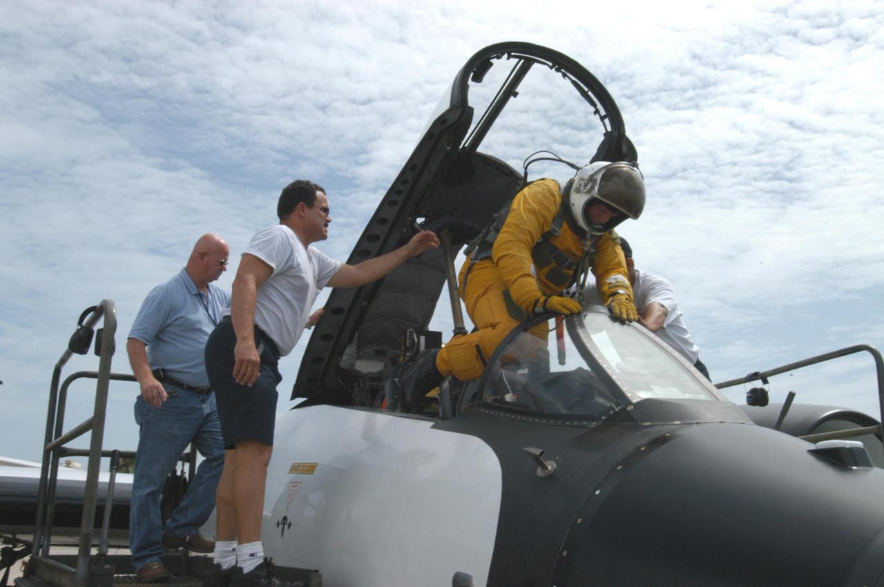 KENNEDY SPACE CENTER, FLA. -  NASA pilot Rick Hull climbs into the cockpit before a test flight of the WB-57F aircraft that will take photos of Space Shuttle Discovery during its launch on Return to Flight mission STS-114.    NASA approved the development and implementation of the aircraft-based imaging system, known as the WB-57 Ascent Video Experiment (WAVE).  The WAVE provides both ascent and entry imagery and enables better observation of the Shuttle on days of heavier cloud cover and areas obscured from ground cameras by the launch exhaust plume. WAVE comprises a 32-inch-ball turret system mounted on the nose of two WB-57 aircraft. The turret houses an optical bench, providing installation of both HDTV and infrared cameras. Optics consist of an 11-inch-diameter, 4.2 meter fixed-focal-length lens. The system can be operated in both auto track and manual modes.