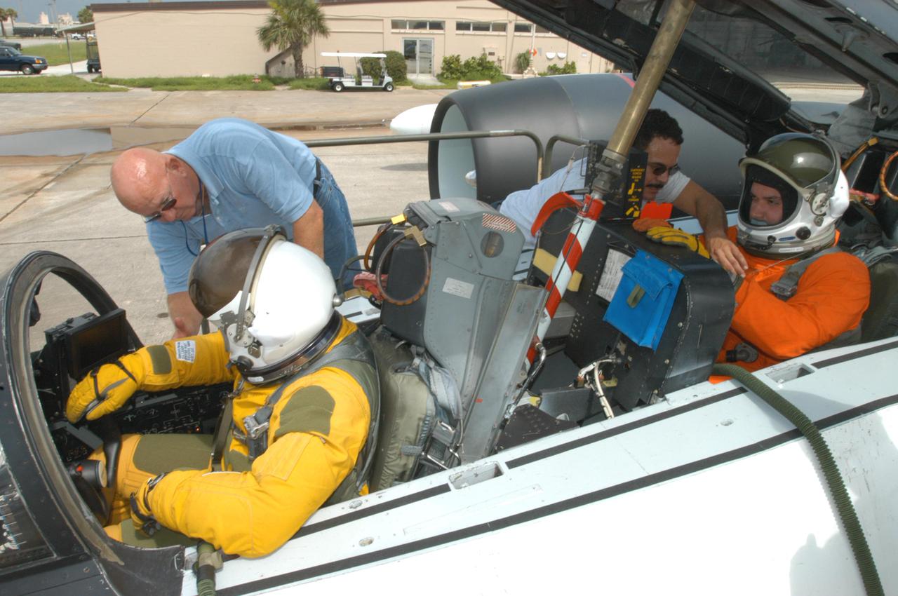 KENNEDY SPACE CENTER, FLA. -  NASA pilot Rick Hull and aerospace engineer Brian Barnett are strapped into their seats in the WB-57F aircraft that will take photos of Space Shuttle Discovery during its launch on Return to Flight mission STS-114. NASA approved the development and implementation of the aircraft-based imaging system, known as the WB-57 Ascent Video Experiment (WAVE).  The WAVE provides both ascent and entry imagery and enables better observation of the Shuttle on days of heavier cloud cover and areas obscured from ground cameras by the launch exhaust plume. WAVE comprises a 32-inch-ball turret system mounted on the nose of two WB-57 aircraft. The turret houses an optical bench, providing installation of both HDTV and infrared cameras. Optics consist of an 11-inch-diameter, 4.2 meter fixed-focal-length lens. The system can be operated in both auto track and manual modes.