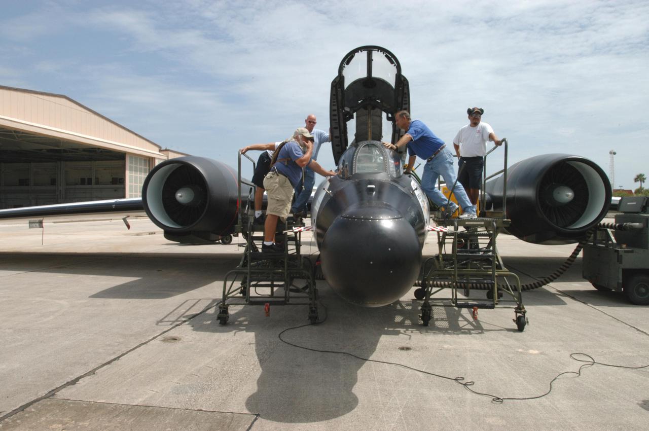 KENNEDY SPACE CENTER, FLA. -  At Patrick Air Force Base in Cocoa Beach, Fla., workers prepare the WB-57F aircraft that will take photos of Space Shuttle Discovery during its launch on Return to Flight mission STS-114.  NASA approved the development and implementation of the aircraft-based imaging system, known as the WB-57 Ascent Video Experiment (WAVE).  The WAVE provides both ascent and entry imagery and enables better observation of the Shuttle on days of heavier cloud cover and areas obscured from ground cameras by the launch exhaust plume. WAVE comprises a 32-inch-ball turret system mounted on the nose of two WB-57 aircraft. The turret houses an optical bench, providing installation of both HDTV and infrared cameras. Optics consist of an 11-inch-diameter, 4.2 meter fixed-focal-length lens. The system can be operated in both auto track and manual modes.