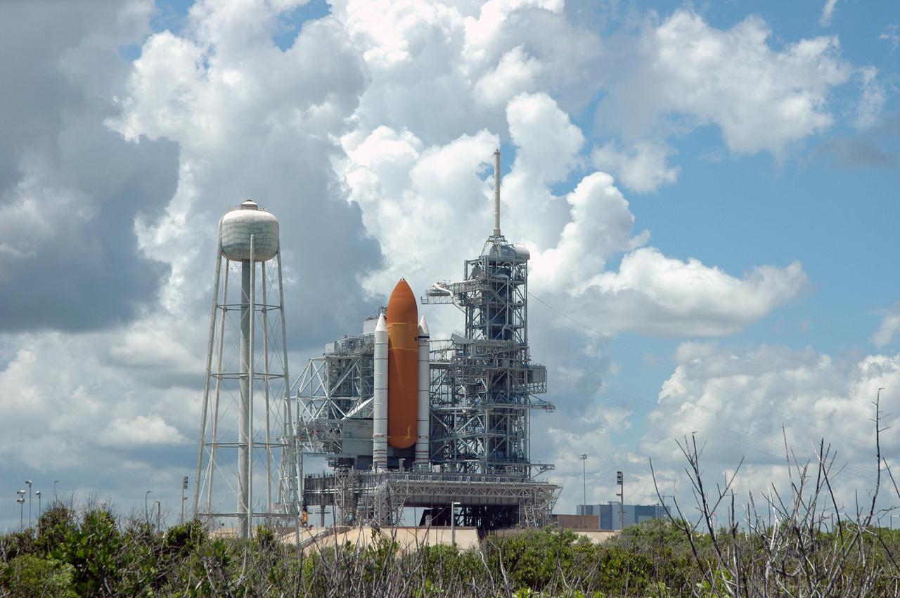 KENNEDY SPACE CENTER, FLA. - Space Shuttle Discovery remains on the pad the day after the Shuttle’s launch on Return to Flight mission STS-114 was scrubbed. The Rotating Service Structure has been closed. At left is the 290-foot-tall water tower that holds 300,000 gallons of water, part of the sound suppression system during a launch. The July 13 mission was scrubbed when a low-level fuel cut-off sensor for the liquid hydrogen tank inside the External Tank failed a routine prelaunch check during the countdown July 13, causing mission managers to scrub Discovery's first launch attempt. The sensor protects the Shuttle's main engines by triggering their shutdown in the event fuel runs unexpectedly low. The sensor is one of four inside the liquid hydrogen section of the External Tank (ET).