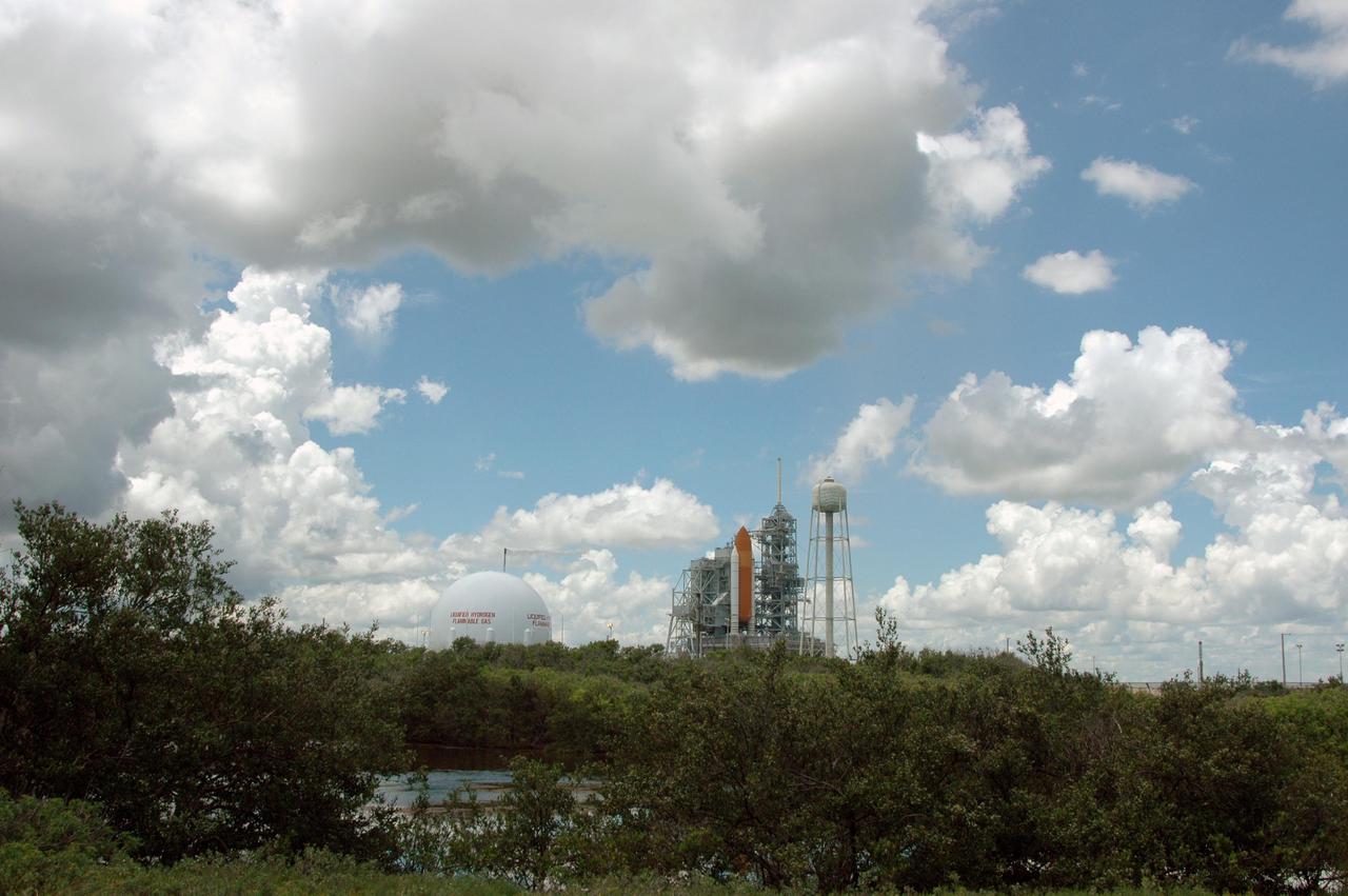 KENNEDY SPACE CENTER, FLA. -   Storm clouds roll across the sky above and beyond Space Shuttle Discovery on Launch Pad 39B.  The Shuttle remains on the pad the day after the Shuttle’s launch on Return to Flight mission STS-114 was scrubbed.   The July 13 mission was scrubbed when a low-level fuel cut-off sensor for the liquid hydrogen tank inside the External Tank failed a routine prelaunch check during the countdown July 13, causing mission managers to scrub Discovery's first launch attempt. The sensor protects the Shuttle's main engines by triggering their shutdown in the event fuel runs unexpectedly low. The sensor is one of four inside the liquid hydrogen section of the External Tank (ET).