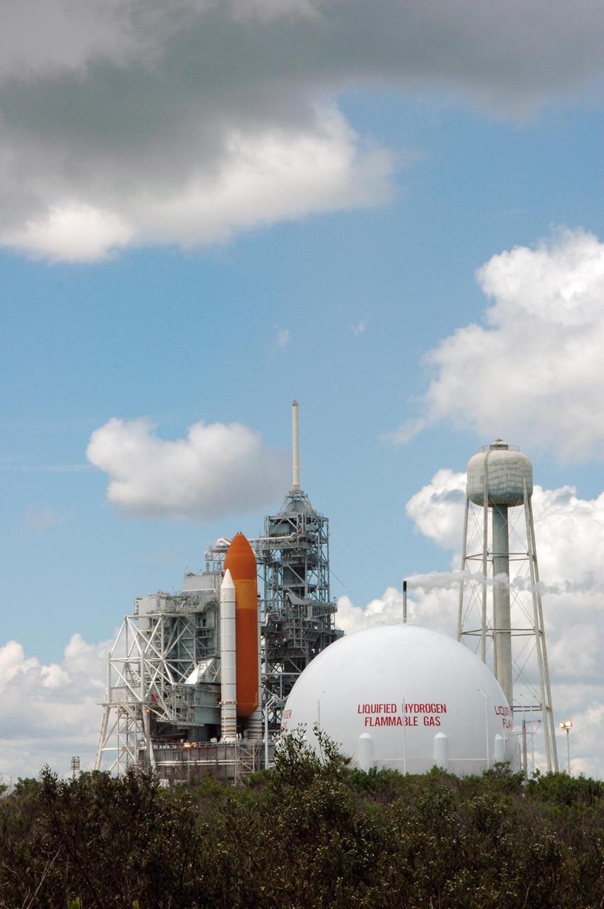 KENNEDY SPACE CENTER, FLA. - Space Shuttle Discovery remains on the pad the day after the Shuttle’s launch on Return to Flight mission STS-114 was scrubbed. In the foreground is the liquid hydrogen storage tank. At right is the 290-foot-tall water tower that holds 300,000 gallons of water, part of the sound suppression system during a launch. The July 13 mission was scrubbed when a low-level fuel cut-off sensor for the liquid hydrogen tank inside the External Tank failed a routine prelaunch check during the countdown July 13, causing mission managers to scrub Discovery's first launch attempt. The sensor protects the Shuttle's main engines by triggering their shutdown in the event fuel runs unexpectedly low. The sensor is one of four inside the liquid hydrogen section of the External Tank (ET).