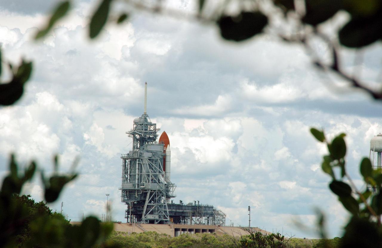 KENNEDY SPACE CENTER, FLA. - Space Shuttle Discovery remains on the pad the day after the Shuttle’s launch on Return to Flight mission STS-114 was scrubbed. In the foreground is the liquid hydrogen storage tank. At right is the 290-foot-tall water tower that holds 300,000 gallons of water, part of the sound suppression system during a launch. The July 13 mission was scrubbed when a low-level fuel cut-off sensor for the liquid hydrogen tank inside the External Tank failed a routine prelaunch check during the countdown July 13, causing mission managers to scrub Discovery's first launch attempt. The sensor protects the Shuttle's main engines by triggering their shutdown in the event fuel runs unexpectedly low. The sensor is one of four inside the liquid hydrogen section of the External Tank (ET).