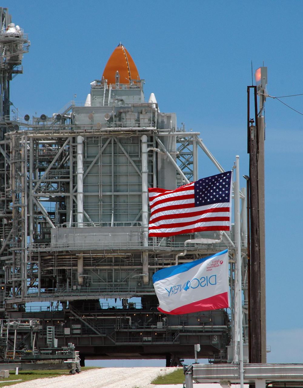 KENNEDY SPACE CENTER, FLA. -   Viewed from the west side of Launch Pad 39B, the Rotating Service Structure surrounds Space Shuttle Discovery after scrub of Return to Flight mission STS-114.   The July 13 mission was scrubbed when a low-level fuel cut-off sensor for the liquid hydrogen tank inside the External Tank failed a routine prelaunch check during the countdown July 13, causing mission managers to scrub Discovery's first launch attempt. The sensor protects the Shuttle's main engines by triggering their shutdown in the event fuel runs unexpectedly low. The sensor is one of four inside the liquid hydrogen section of the External Tank (ET).