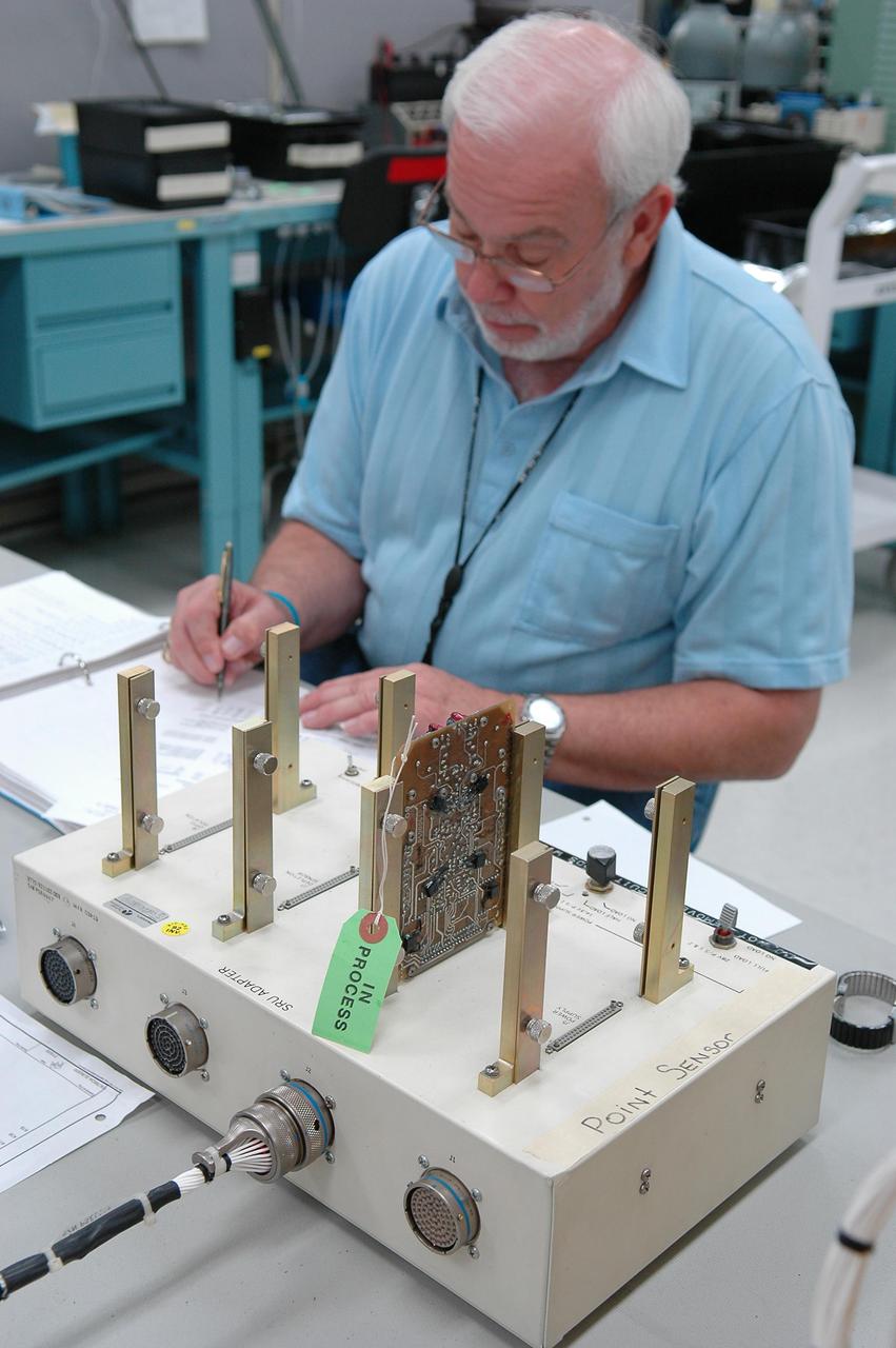 KENNEDY SPACE CENTER, FLA. -   Lloyd Pierce, a NASA test engineer, checks electronic components related to the faulty sensor readings in the liquid hydrogen tank low-level fuel cut-off sensor. The sensor failed a routine prelaunch check during the launch July 13, causing mission managers to scrub Discovery's first launch attempt. The sensor protects the Shuttle's main engines by triggering their shutdown in the event fuel runs unexpectedly low. The sensor is one of four inside the liquid hydrogen section of the External Tank (ET).
