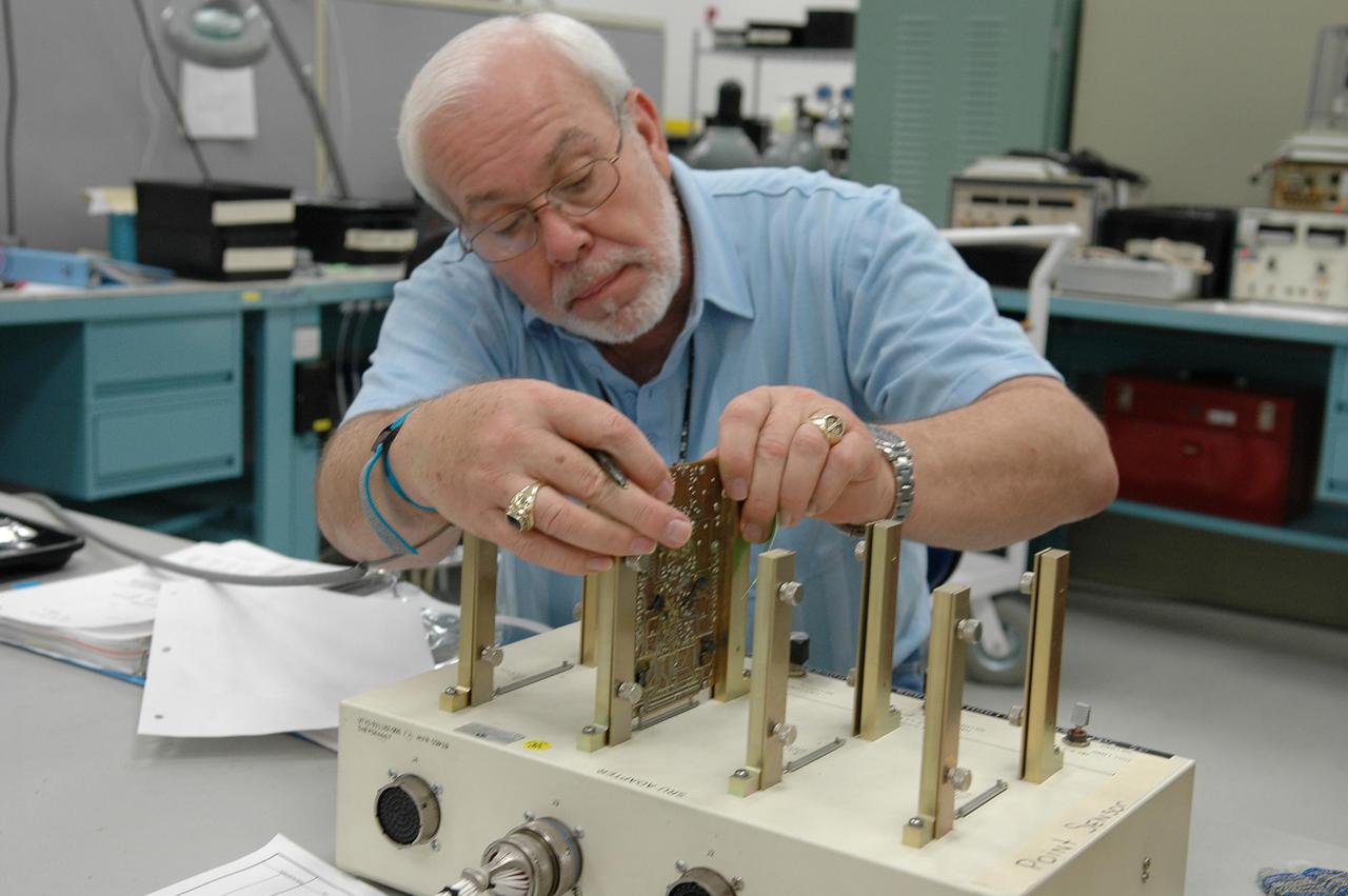 KENNEDY SPACE CENTER, FLA. -   Lloyd Pierce, a NASA test engineer, checks electronic components related to the faulty sensor readings in the liquid hydrogen tank low-level fuel cut-off sensor. The sensor failed a routine prelaunch check during the launch July 13, causing mission managers to scrub Discovery's first launch attempt. The sensor protects the Shuttle's main engines by triggering their shutdown in the event fuel runs unexpectedly low. The sensor is one of four inside the liquid hydrogen section of the External Tank (ET).