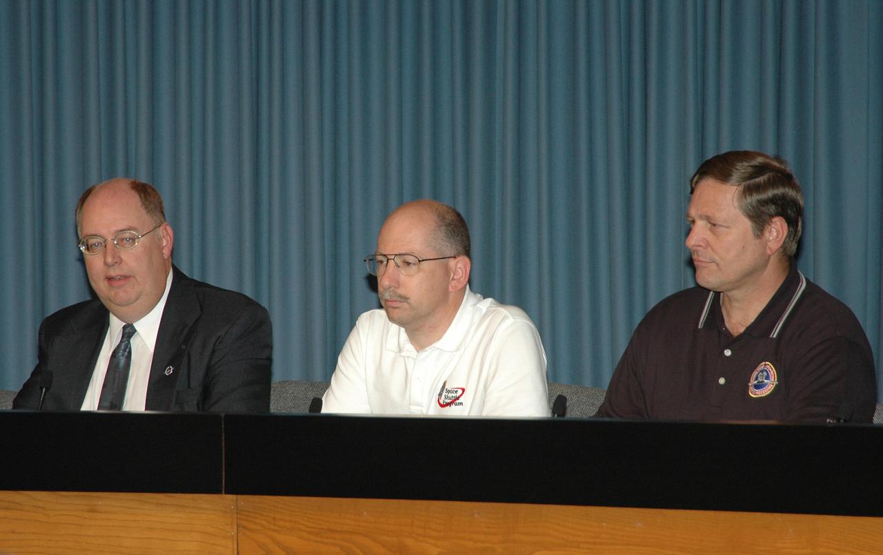 KENNEDY SPACE CENTER, FLA. -   At a press conference, members of the Mission Management Team reveal aspects of the troubleshooting and testing being done on the liquid hydrogen tank low-level fuel cut-off sensor. From left are Wayne Hale, Space Shuttle deputy program manager; John Muratore, manager of Systems Engineering and Integration for the Space Shuttle Program; and Mike Wetmore, director of Space Shuttle Processing. The sensor failed a routine prelaunch check during the launch countdown July 13, causing mission managers to scrub Discovery's first launch attempt. The sensor protects the Shuttle's main engines by triggering their shutdown in the event fuel runs unexpectedly low. The sensor is one of four inside the liquid hydrogen section of the External Tank (ET).