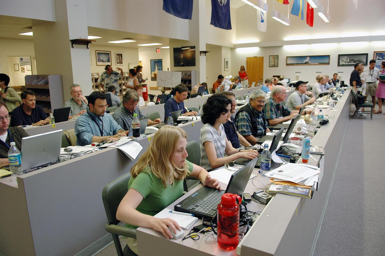 KENNEDY SPACE CENTER, FLA. -    Journalists fill the work stations at the NASA News Center while others find standing room only during launch activities for Return to Flight mission STS-114.  More than a thousand media representatives from 36 states, the District of Columbia and 32 countries converged on the News Center for the historic launch.