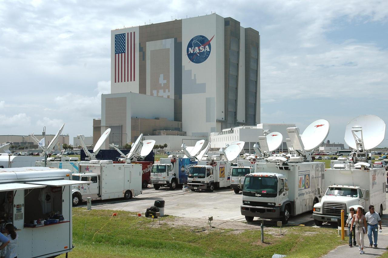KENNEDY SPACE CENTER, FLA. -   Satellite trucks are lined up in the parking lot at the NASA Kennedy Space Center News Center to cover the launch of Space Shuttle Discovery on Return to Flight mission STS-114.  In the background is the Vehicle Assembly Building. More than a thousand media representatives from 36 states, the District of Columbia and 32 countries converged on the News Center for the historic launch.