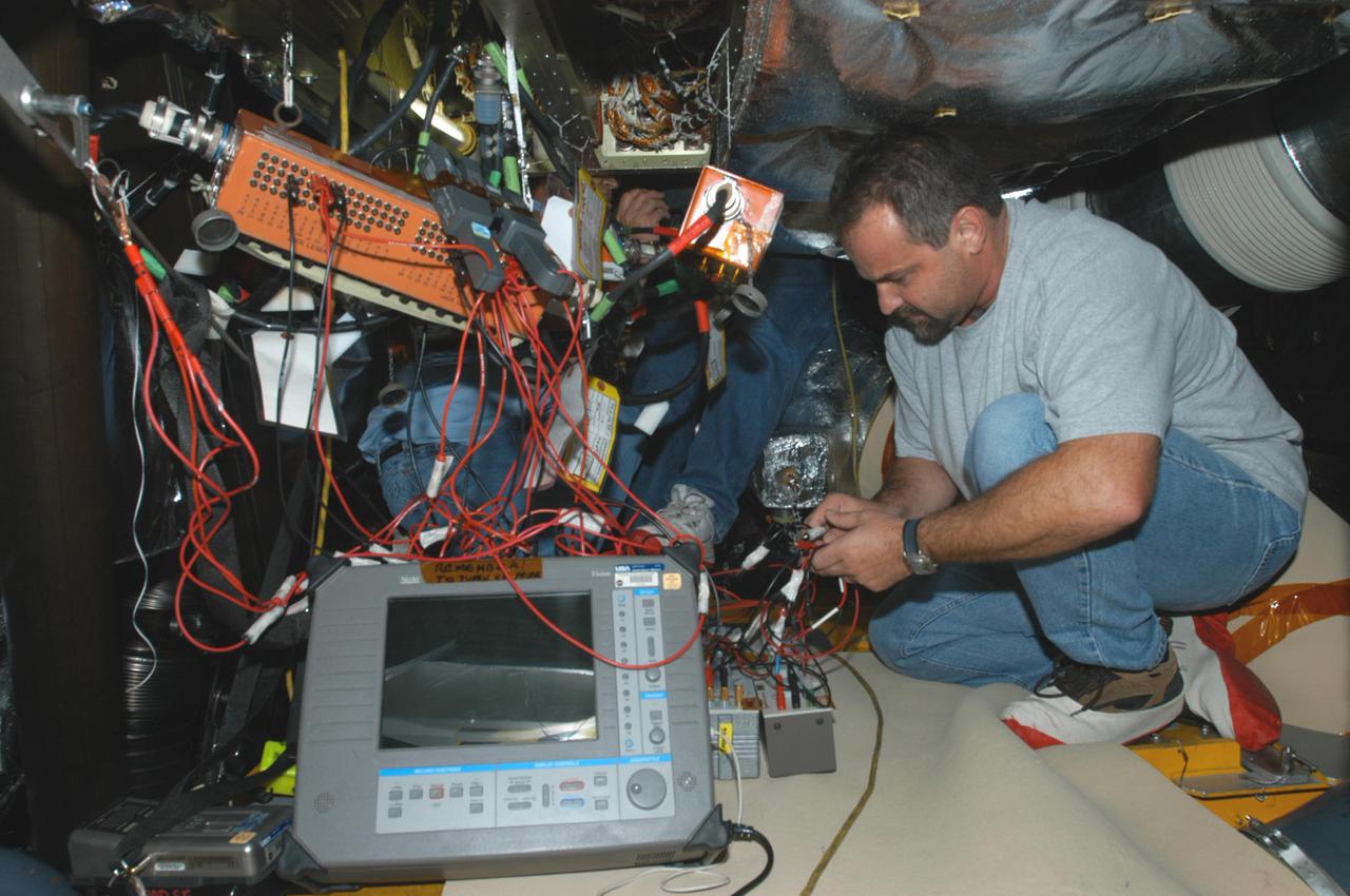 KENNEDY SPACE CENTER, FLA. -   Jack Colella, with United Space Alliance, is conducting electromagnetic interference and ground resistance testing on wiring in the aft engine compartment on Space Shuttle Discovery using various test equipment, such as current probes, amp meters, digital volt meters, breakout boxes, Nicollet recorders, oscilloscopes and time domain reflectometers.   Other testing will evaluate wiring runs and connections for any reactions under semi-cryogenic conditions. Engineering teams have been working through a troubleshooting plan to address an issue with a liquid hydrogen low-level fuel sensor circuit. The sensor circuit failed a routine prelaunch check during the countdown July 13, delaying Discovery’s first launch attempt on Return to Flight mission STS-114.