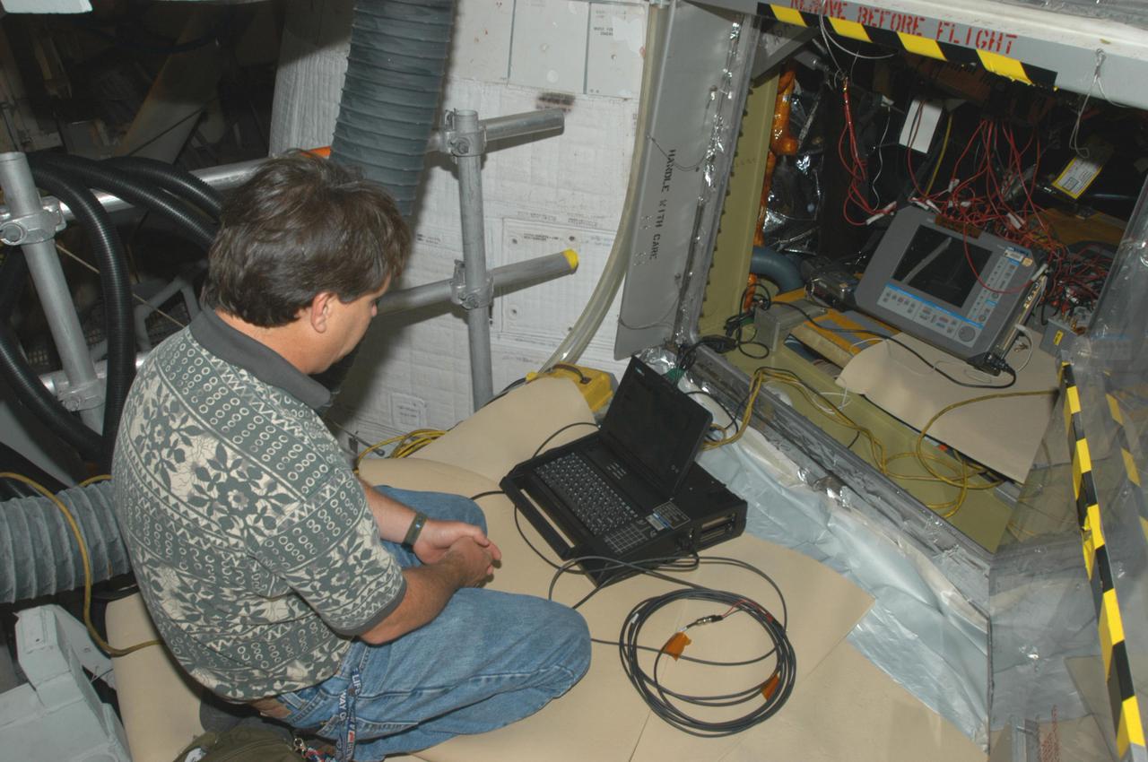 KENNEDY SPACE CENTER, FLA. -   Jeff Huet, with United Space Alliance,  is conducting electromagnetic interference and ground resistance testing on wiring in the aft engine compartment on Space Shuttle Discovery using various test equipment, such as current probes, amp meters, digital volt meters, breakout boxes, Nicollet recorders, oscilloscopes and time domain reflectometers.   Other testing will evaluate wiring runs and connections for any reactions under semi-cryogenic conditions. Other testing will evaluate wiring runs and connections for any reactions under semi-cryogenic conditions, using a Nicolet data recorder.  Engineering teams have been working through a troubleshooting plan to address an issue with a liquid hydrogen low-level fuel sensor circuit. The sensor circuit failed a routine prelaunch check during the countdown July 13, delaying Discovery’s first launch attempt on Return to Flight mission STS-114.