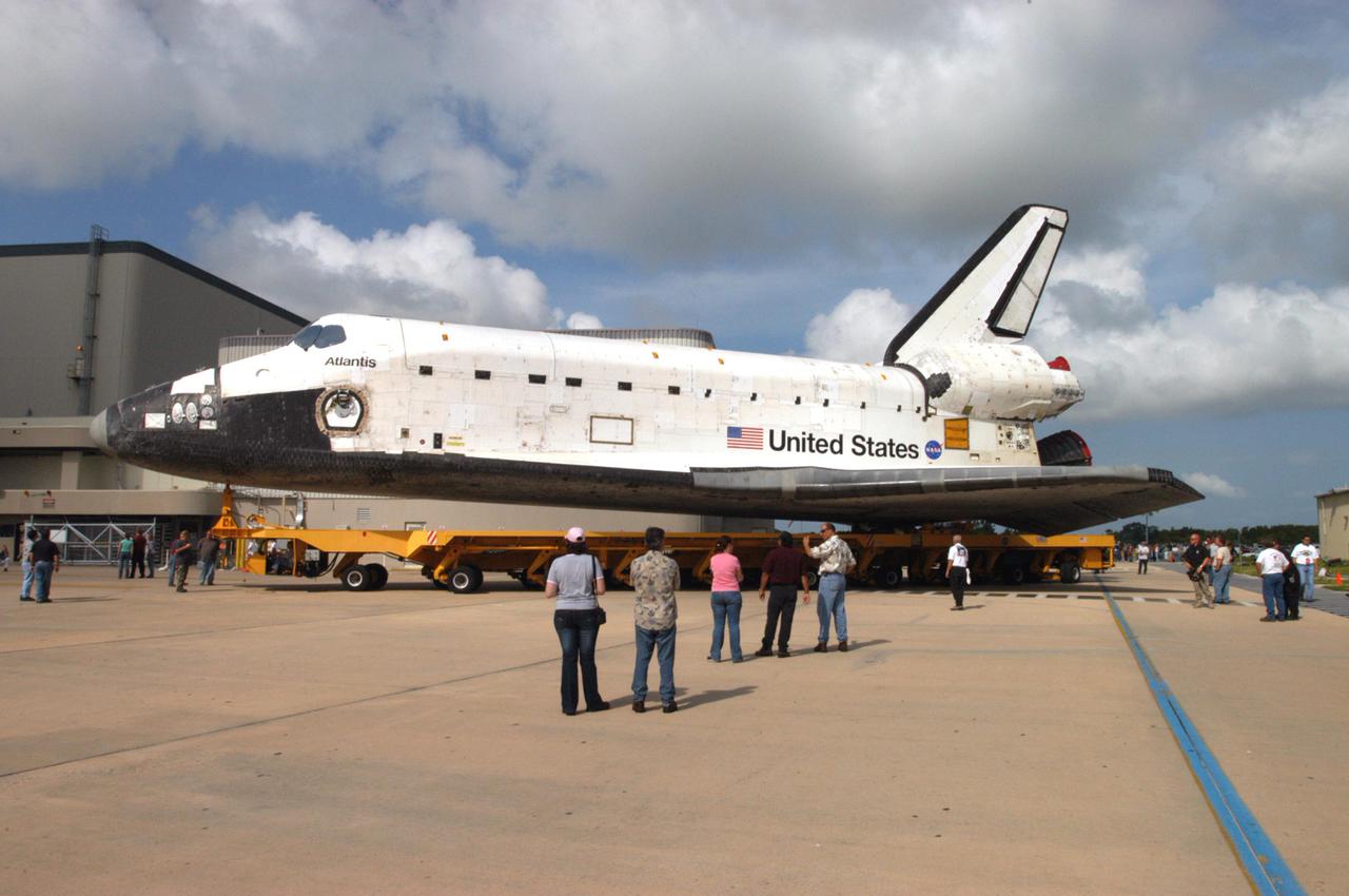 KENNEDY SPACE CENTER, FLA. -   The orbiter Atlantis, on top of the orbiter transporter, begins its turn after rolling out of the Orbiter Processing Facility, heading for the Vehicle Assembly Building (VAB).  In the VAB it will be mated with the twin Solid Rocket Boosters and External Tank already stacked on the Mobile Launcher Platform.   Atlantis is being readied for mission STS-121, the second Return to Flight mission to the International Space Station.  This is Atlantis’ 27th space flight and the mission is the 18th flight to the Space Station.  It is a Utilization and Logistics Flight.  Launch is scheduled during a planning window between Sept. 9 and Sept. 24.