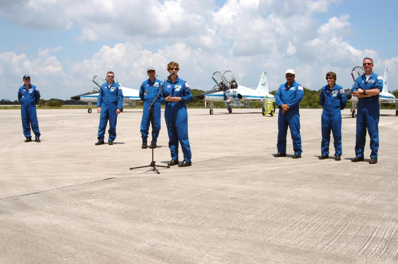 KENNEDY SPACE CENTER, FLA. - On NASA Kennedy Space Center’s Shuttle Landing Facility, the Return to Flight STS-114 crew waits while Mission Commander Eileen Collins talks to the media. Seen in the photo are (from left) Mission Specialist Andrew Thomas, Pilot James Kelly, Mission Specialist Soichi Noguchi, Collins, and Mission Specialists Charles Camarda, Wendy Lawrence and Stephen Robinson. Collins states that since the scrub on July 13, the crew has focused on the on-orbit part of the mission and training for night landings using the Shuttle Training Aircraft. She praised the engineers and technicians who have been troubleshooting the elusive sensor problem and thanked them. STS-114 is scheduled to launch July 26 at 10:39 a.m. EDT from Launch Pad 39B.
