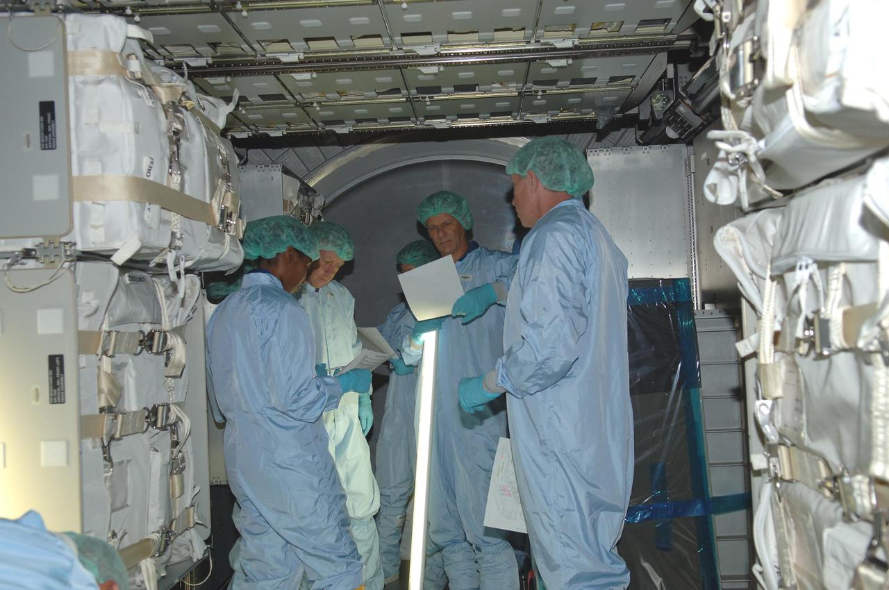 KENNEDY SPACE CENTER, FLA. - Members of the STS-121 crew take part in Crew Equipment Interface Test activities in the Space Station Processing Facility at NASA Kennedy Space Center. Here they are looking at elements inside the the Multi-Purpose Logistics Module Leonardo, which is part of the payload on the mission. STS-121, the second Return to Flight mission, is targeted for launch in a lighted planning window of Sept. 9 to Sept. 25.