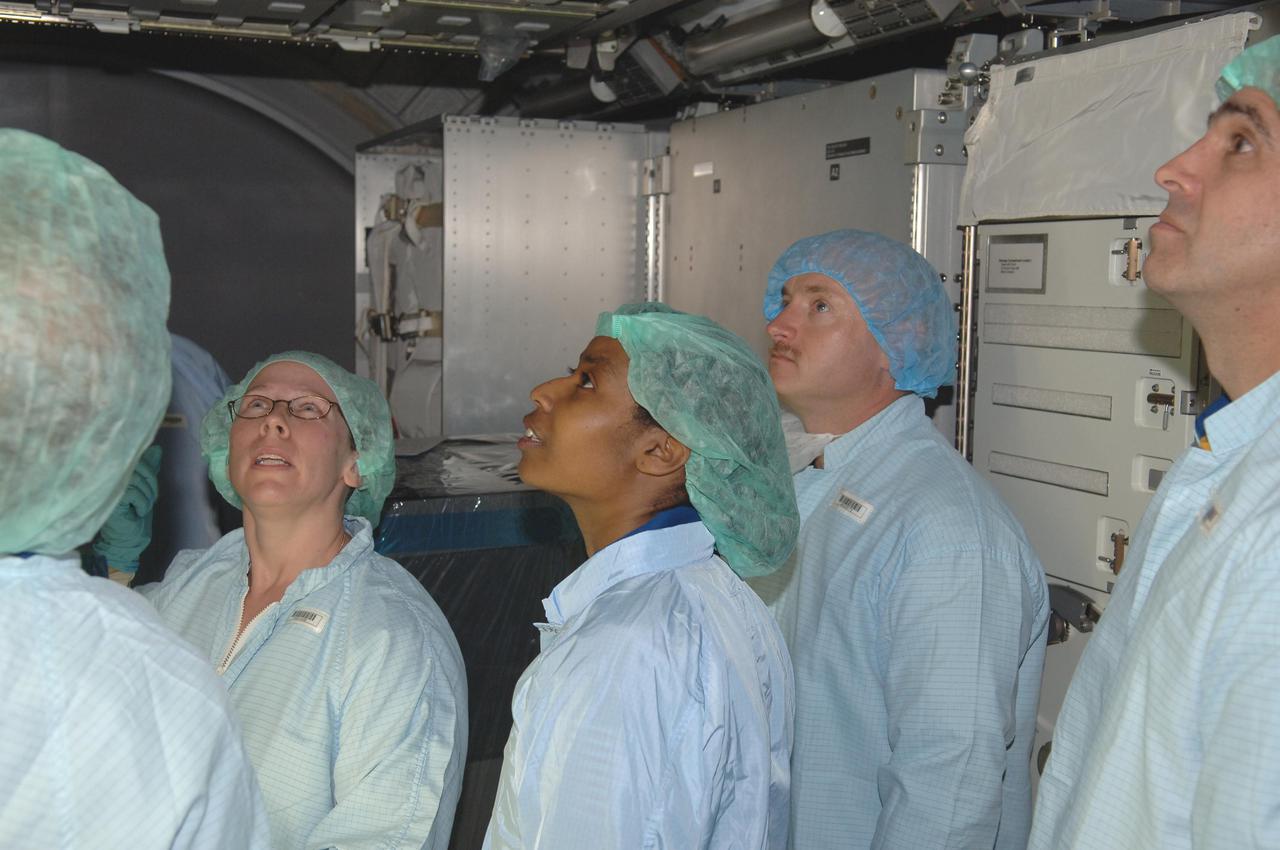 KENNEDY SPACE CENTER, FLA. -   In the Space Station Processing Facility at NASA Kennedy Space Center, members of the STS-121 crew look at elements inside the Multi-Purpose Logistics Module Leonardo, which is part of the payload on the mission.  The crew is at KSC to take part in Crew Equipment Interface Test activities, which provide hands-on experience with equipment they will use on-orbit.  STS-121, the second Return to Flight mission, is targeted for launch in a lighted planning window of Sept. 9 to Sept. 25.