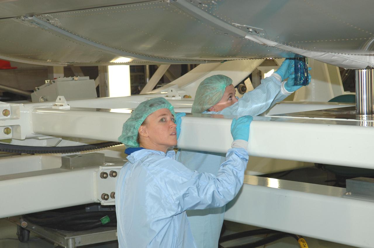 KENNEDY SPACE CENTER, FLA. -   In the Space Station Processing Facility at NASA Kennedy Space Center, members of the STS-121 crew look at the underside of the Multi-Purpose Logistics Module Leonardo, which is part of the payload on the mission.  The crew is at KSC to take part in Crew Equipment Interface Test activities, which provide hands-on experience with equipment they will use on-orbit.  STS-121, the second Return to Flight mission, is targeted for launch in a lighted planning window of Sept. 9 to Sept. 25.