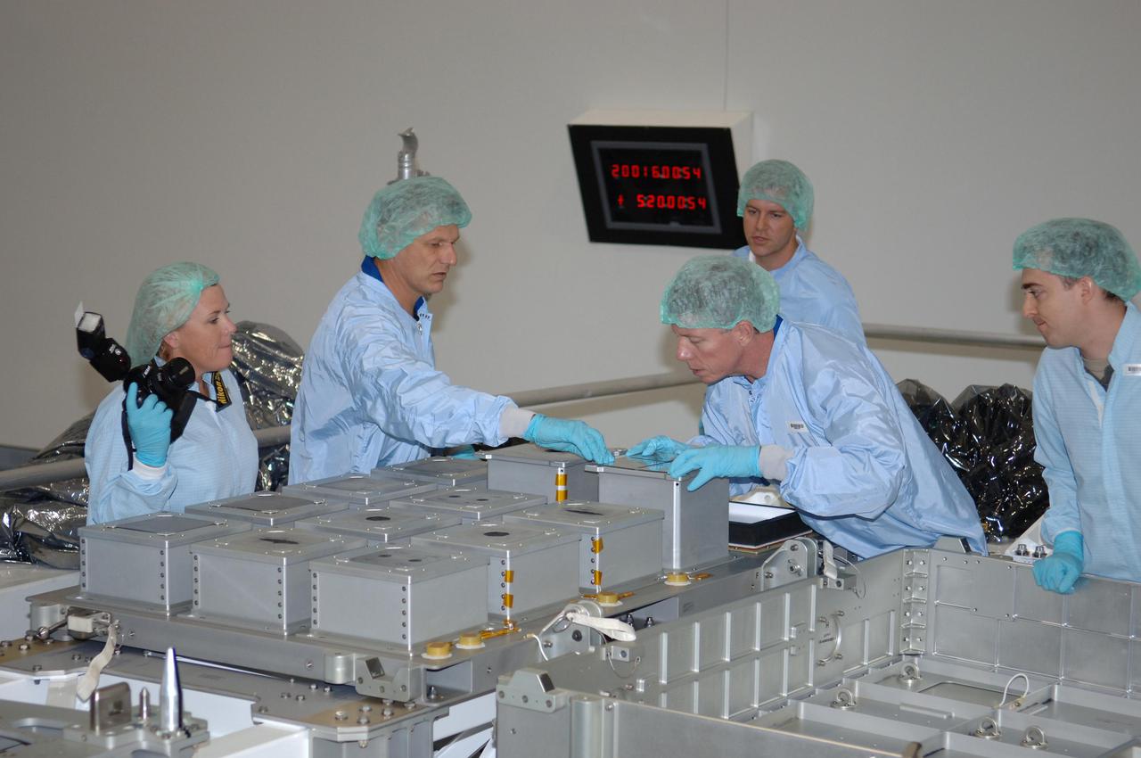 KENNEDY SPACE CENTER, FLA. - In the Space Station Processing Facility at NASA Kennedy Space Center, members of the STS-121 crew look at the Detailed Test Objective (DTO) tile sample repair kit situated on the Lightweight Multi-Purpose Experiment Support Structure Carrier (LMC). The crew is at KSC to take part in Crew Equipment Interface Test activities, which provide hands-on experience with equipment they will use on-orbit. STS-121, the second Return to Flight mission, is targeted for launch in a lighted planning window of Sept. 9 to Sept. 25.