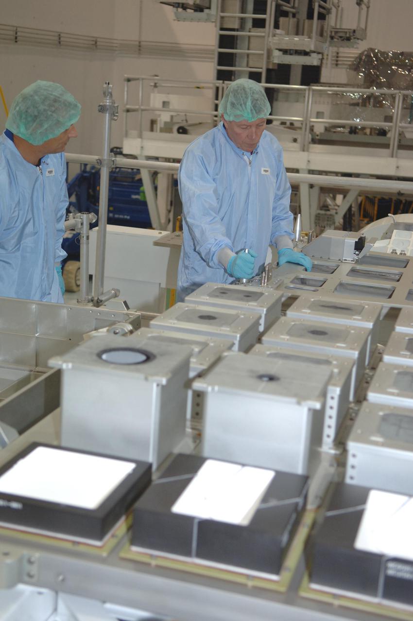 KENNEDY SPACE CENTER, FLA. - In the Space Station Processing Facility at NASA Kennedy Space Center, STS-121 Mission Specialist Michael Fossum works with the Detailed Test Objective (DTO) tile sample repair kit situated on the Lightweight Multi-Purpose Experiment Support Structure Carrier (LMC). The crew is at KSC to take part in Crew Equipment Interface Test activities, which provide hands-on experience with equipment they will use on-orbit. STS-121, the second Return to Flight mission, is targeted for launch in a lighted planning window of Sept. 9 to Sept. 25.