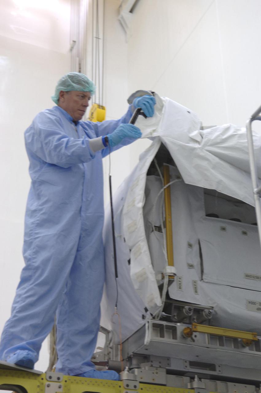 KENNEDY SPACE CENTER, FLA. - At Astrotech Space Operations in Titusville, Fla., STS-121 Mission Commander takes a look at a pump module. The STS-121 crew is at KSC to take part in Crew Equipment Interface Test activities, which provide hands-on experience with equipment they will use on-orbit. STS-121, the second Return to Flight mission, is targeted for launch in a lighted planning window of Sept. 9 to Sept. 25.