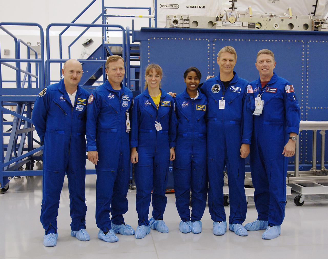 KENNEDY SPACE CENTER, FLA. -  At Astrotech Space Operations in Titusville, Fla., the STS-121 crew poses for a photo.  From left are Pilot Mark Kelly, Mission Commander Steven Lindsey, and Mission Specialists Lisa Nowak, Stephanie Wilson, Piers Sellers and Michael Fossum.  The STS-121 crew is at KSC to take part in Crew Equipment Interface Test activities, which provide hands-on experience with equipment they will use on-orbit.  STS-121, the second Return to Flight mission, is targeted for launch in a lighted planning window of Sept. 9 to Sept. 25.