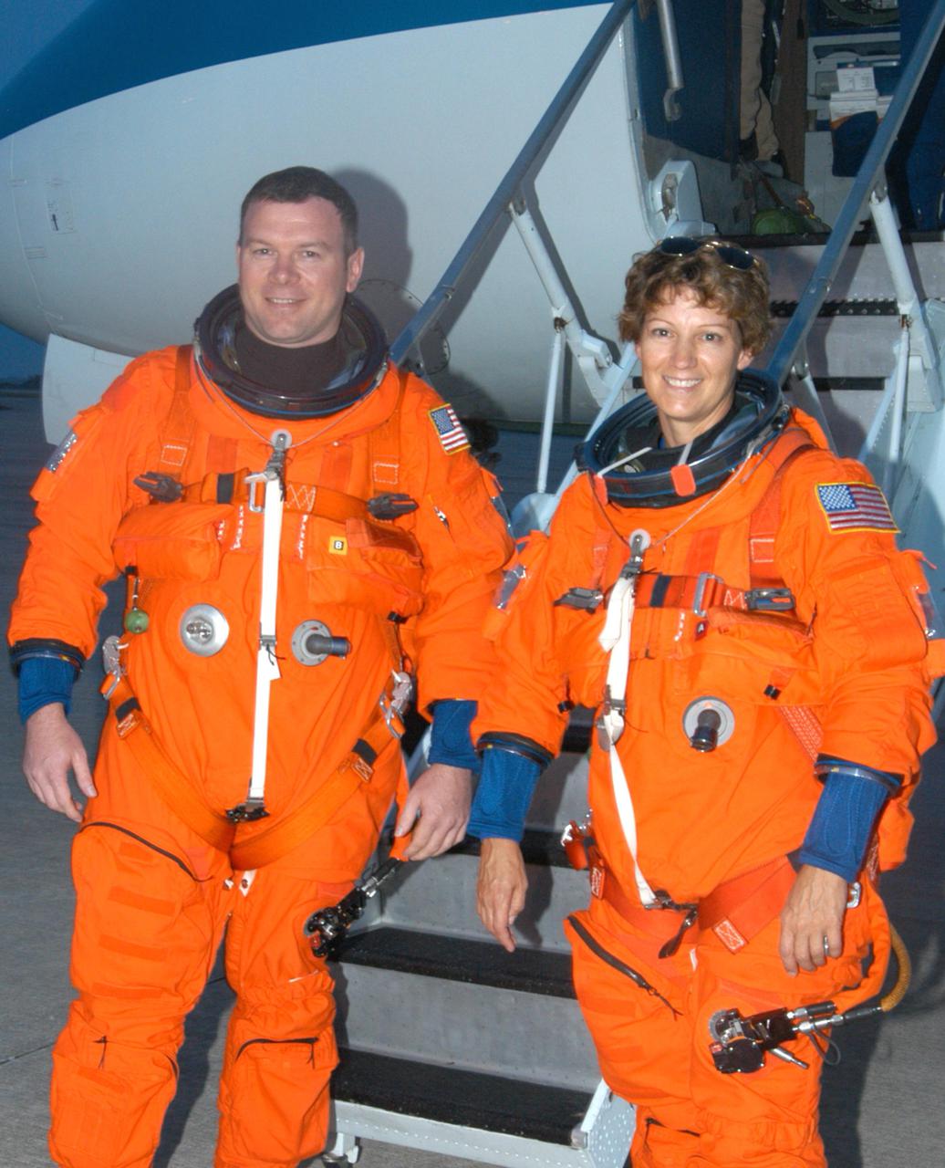 KENNEDY SPACE CENTER, FLA. - At the Shuttle Landing Facility on NASA Kennedy Space Center, STS-114 Pilot James Kelly (left) and Mission Commander Eileen Collins pause for a photo after exiting the Shuttle Training Aircraft (STA) behind them. Collins and Kelly have been practicing night landings in the STA in preparation for the mission. The STA is a modified Grumman American Aviation-built Gulf Stream II executive jet that was modified to simulate an orbiter’s cockpit, motion and visual cues, and handling qualities. In flight, the STA duplicates the orbiter’s atmospheric descent trajectory from approximately 35,000 feet altitude to landing on a runway. Because the orbiter is unpowered during re-entry and landing, its high-speed glide must be perfectly executed the first time. Return to Flight Mission STS-114 is scheduled to launch aboard Space Shuttle Discovery with a crew of seven at 10:39 a.m. EDT on July 26. Landing is expected on Aug. 7.