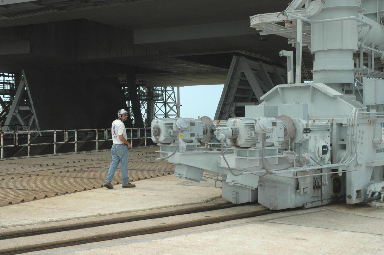 KENNEDY SPACE CENTER, FLA. - A worker on Launch Pad 39B at NASA Kennedy Space Center walks alongside the track of the Rotating Service Structure as it begins rolling back from its position around Space Shuttle Discovery. Rollback of the RSS is a major preflight milestone, typically occurring during the T-11-hour hold on L-1 (the day before launch). Discovery is scheduled to lift off on the historic Return to Flight mission STS-114 at 10:39 a.m. EDT July 26 with a crew of seven.  On the mission to the International Space Station the crew will perform inspections on orbit for the first time of all of the Reinforced Carbon-Carbon (RCC) panels on the leading edge of the wings and the Thermal Protection System tiles using the new Canadian-built Orbiter Boom Sensor System and the data from 176 impact and temperature sensors. Mission Specialists will also practice repair techniques on RCC and tile samples during a spacewalk in the payload bay.  During two additional spacewalks, the crew will install the External Stowage Platform-2, equipped with spare part assemblies, and a replacement Control Moment Gyroscope contained in the Lightweight Multi-Purpose Experiment Support Structure.