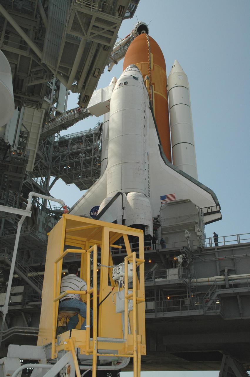 KENNEDY SPACE CENTER, FLA. - A worker on Launch Pad 39B at NASA Kennedy Space Center sits in the control cab of the Rotating Service Structure as it begins rolling back from its position around Space Shuttle Discovery. Rollback of the RSS is a major preflight milestone, typically occurring during the T-11-hour hold on L-1 (the day before launch). Discovery is scheduled to lift off on the historic Return to Flight mission STS-114 at 10:39 a.m. EDT July 26 with a crew of seven.  On the mission to the International Space Station the crew will perform inspections on orbit for the first time of all of the Reinforced Carbon-Carbon (RCC) panels on the leading edge of the wings and the Thermal Protection System tiles using the new Canadian-built Orbiter Boom Sensor System and the data from 176 impact and temperature sensors. Mission Specialists will also practice repair techniques on RCC and tile samples during a spacewalk in the payload bay.  During two additional spacewalks, the crew will install the External Stowage Platform-2, equipped with spare part assemblies, and a replacement Control Moment Gyroscope contained in the Lightweight Multi-Purpose Experiment Support Structure.
