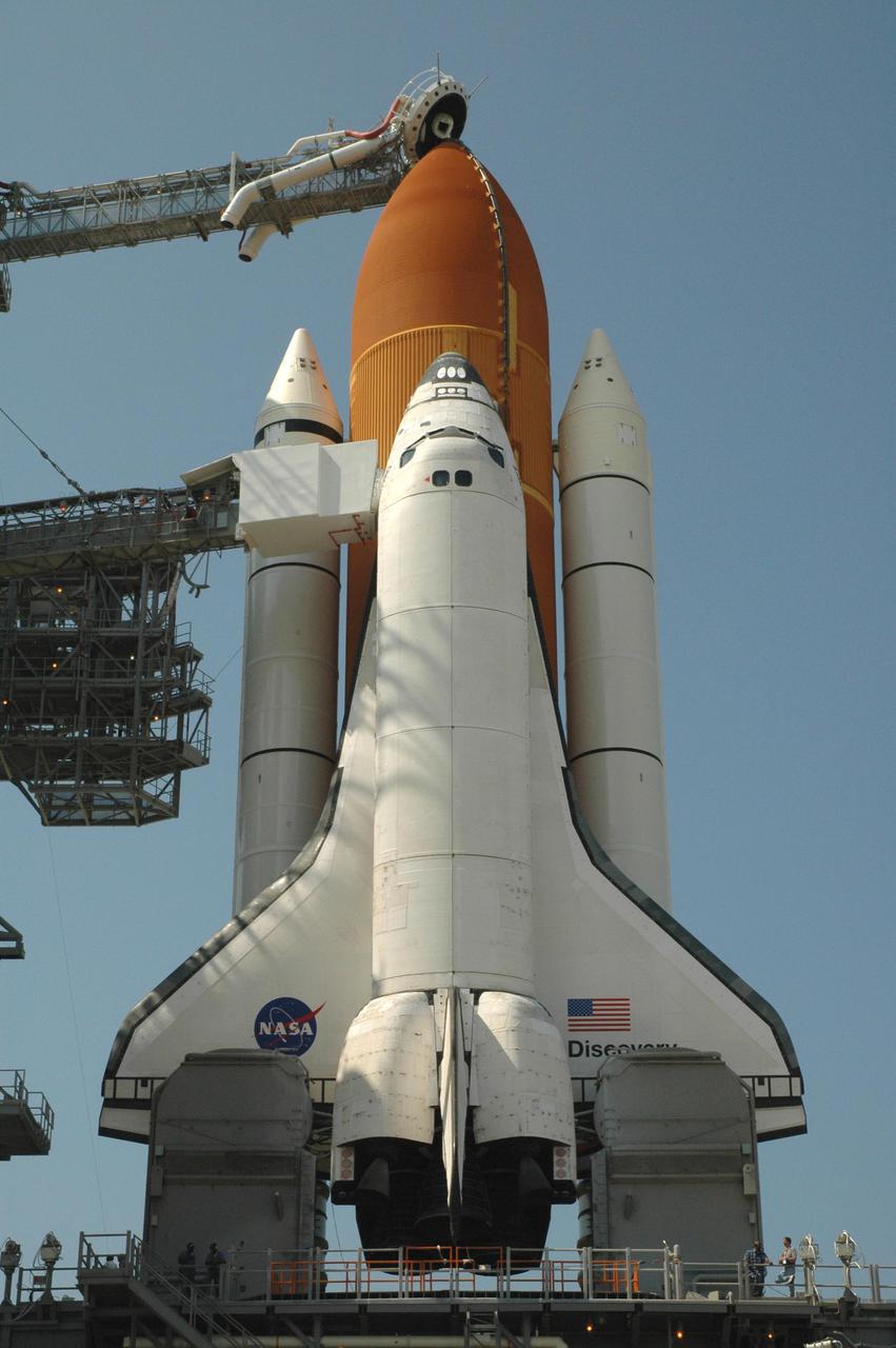 KENNEDY SPACE CENTER, FLA. - Space Shuttle Discovery in full launch configuration is revealed after the Rotating Service Structure (RSS) is rotated back at Launch Pad 39B at NASA Kennedy Space Center.  The gaseous oxygen vent arm (beanie cap) has been extended to the top of the External Tank and the orbiter access arm is extended to Discovery’s hatch. Rollback of the RSS is a major preflight milestone, typically occurring during the T-11-hour hold on L-1 (the day before launch). Discovery is scheduled to lift off on the historic Return to Flight mission STS-114 at 10:39 a.m. EDT July 26 with a crew of seven.  On the mission to the International Space Station the crew will perform inspections on orbit for the first time of all of the Reinforced Carbon-Carbon (RCC) panels on the leading edge of the wings and the Thermal Protection System tiles using the new Canadian-built Orbiter Boom Sensor System and the data from 176 impact and temperature sensors. Mission Specialists will also practice repair techniques on RCC and tile samples during a spacewalk in the payload bay.  During two additional spacewalks, the crew will install the External Stowage Platform-2, equipped with spare part assemblies, and a replacement Control Moment Gyroscope contained in the Lightweight Multi-Purpose Experiment Support Structure.