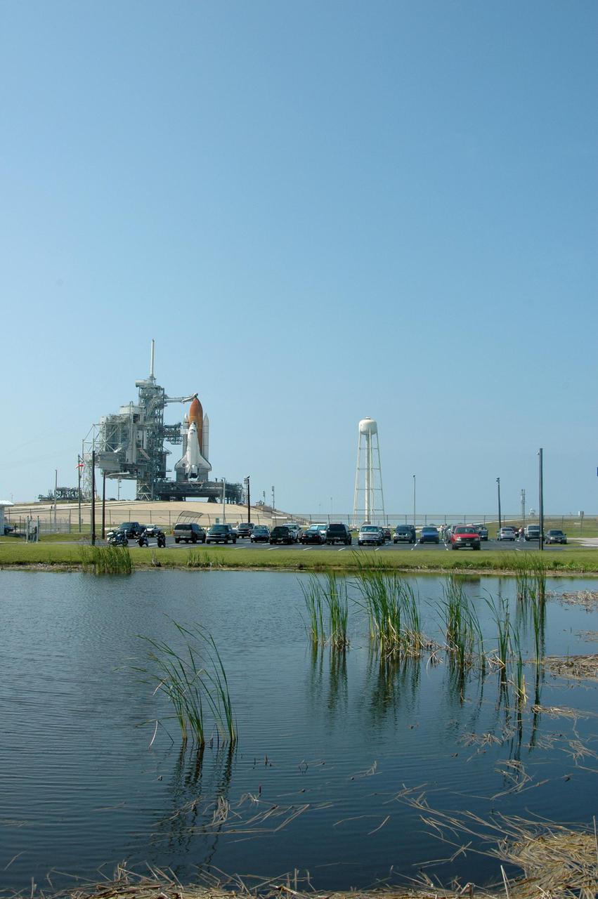 KENNEDY SPACE CENTER, FLA. - Cameras at the edge of a pond have a pristine view to Launch Pad 39B at NASA Kennedy Space Center where the Space Shuttle Discovery waits for launch.  On the right of the Shuttle is the 290-foot-tall water tower that holds 300,000 gallons of water, part of the sound suppression system during a launch.  Discovery is scheduled to lift off on the historic Return to Flight mission STS-114 at 10:39 a.m. EDT July 26 with a crew of seven.  On the mission to the International Space Station the crew will perform inspections on orbit for the first time of all of the Reinforced Carbon-Carbon (RCC) panels on the leading edge of the wings and the Thermal Protection System tiles using the new Canadian-built Orbiter Boom Sensor System and the data from 176 impact and temperature sensors. Mission Specialists will also practice repair techniques on RCC and tile samples during a spacewalk in the payload bay.  During two additional spacewalks, the crew will install the External Stowage Platform-2, equipped with spare part assemblies, and a replacement Control Moment Gyroscope contained in the Lightweight Multi-Purpose Experiment Support Structure.