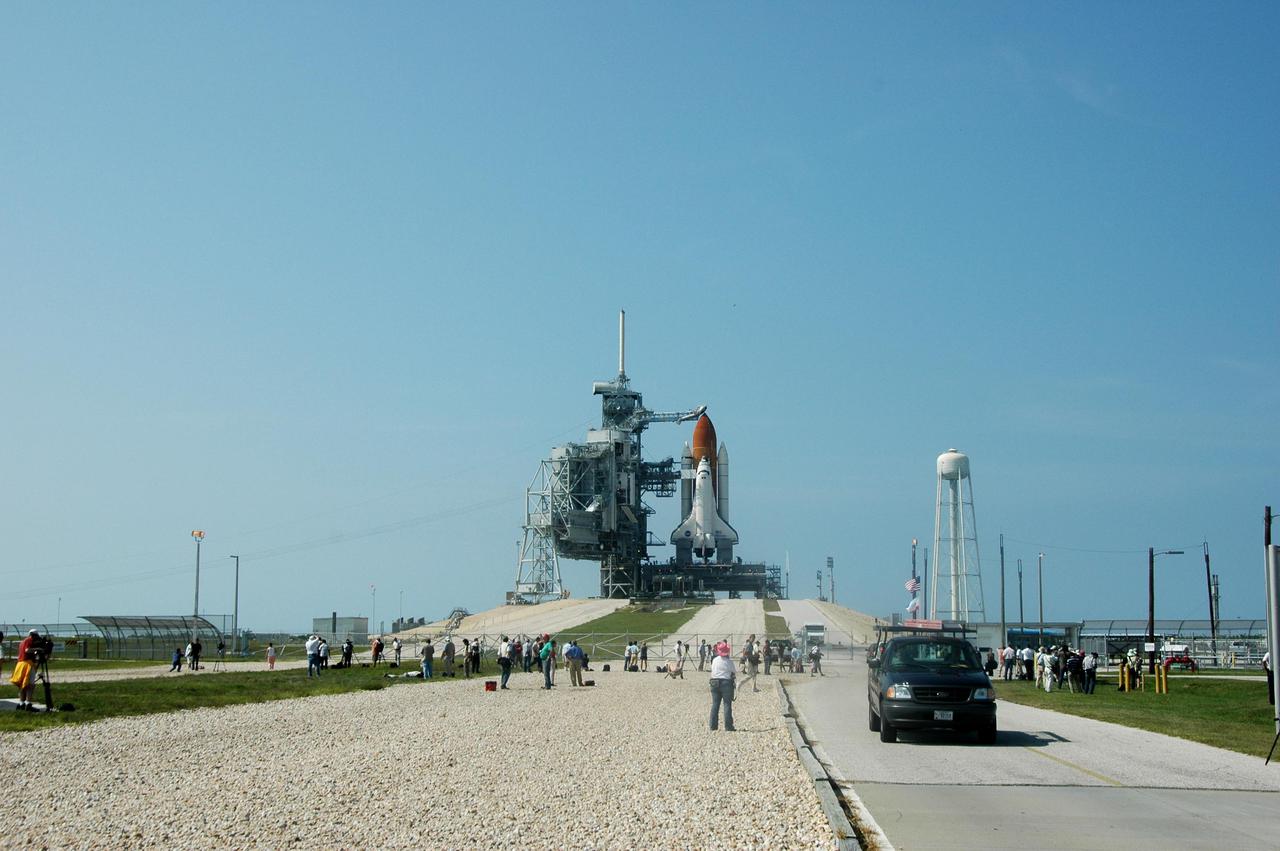 KENNEDY SPACE CENTER, FLA. - After rollback of the Rotating Service Structure on NASA Kennedy Space Center’s Launch Pad 39B, photographers gather at the fence to capture Space Shuttle Discovery revealed in full launch configuration.  Discovery is scheduled to lift off on the historic Return to Flight mission STS-114 at 10:39 a.m. EDT July 26 with a crew of seven.  On the mission to the International Space Station the crew will perform inspections on orbit for the first time of all of the Reinforced Carbon-Carbon (RCC) panels on the leading edge of the wings and the Thermal Protection System tiles using the new Canadian-built Orbiter Boom Sensor System and the data from 176 impact and temperature sensors. Mission Specialists will also practice repair techniques on RCC and tile samples during a spacewalk in the payload bay.  During two additional spacewalks, the crew will install the External Stowage Platform-2, equipped with spare part assemblies, and a replacement Control Moment Gyroscope contained in the Lightweight Multi-Purpose Experiment Support Structure.
