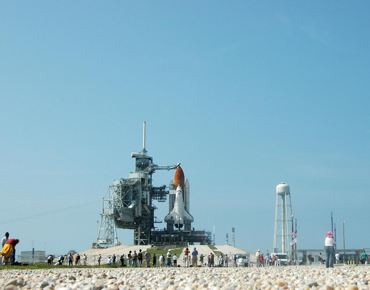 KENNEDY SPACE CENTER, FLA. - After rollback of the Rotating Service Structure on NASA Kennedy Space Center’s Launch Pad 39B, photographers gather at the fence to capture Space Shuttle Discovery revealed in full launch configuration.  Discovery is scheduled to lift off on the historic Return to Flight mission STS-114 at 10:39 a.m. EDT July 26 with a crew of seven.  On the mission to the International Space Station the crew will perform inspections on orbit for the first time of all of the Reinforced Carbon-Carbon (RCC) panels on the leading edge of the wings and the Thermal Protection System tiles using the new Canadian-built Orbiter Boom Sensor System and the data from 176 impact and temperature sensors. Mission Specialists will also practice repair techniques on RCC and tile samples during a spacewalk in the payload bay.  During two additional spacewalks, the crew will install the External Stowage Platform-2, equipped with spare part assemblies, and a replacement Control Moment Gyroscope contained in the Lightweight Multi-Purpose Experiment Support Structure.