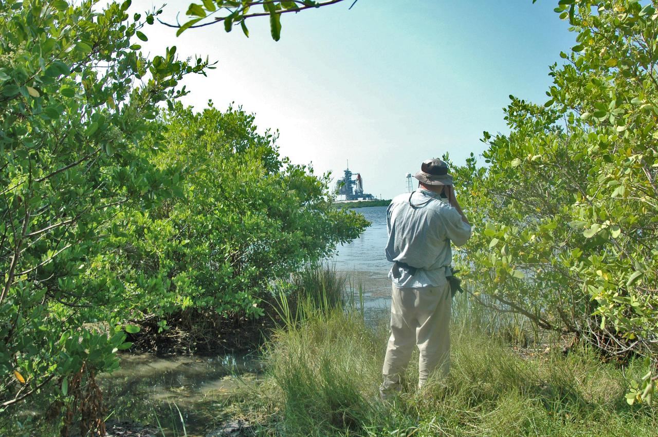 KENNEDY SPACE CENTER, FLA. - This professional photographer is one of hundreds who are gathered at NASA Kennedy Space Center to capture the historic launch of Space Shuttle Discovery, seen on Launch Pad 39B on the horizon.  Discovery is scheduled to lift off on the historic Return to Flight mission STS-114 at 10:39 a.m. EDT July 26 with a crew of seven.  On the mission to the International Space Station the crew will perform inspections on orbit for the first time of all of the Reinforced Carbon-Carbon (RCC) panels on the leading edge of the wings and the Thermal Protection System tiles using the new Canadian-built Orbiter Boom Sensor System and the data from 176 impact and temperature sensors. Mission Specialists will also practice repair techniques on RCC and tile samples during a spacewalk in the payload bay.  During two additional spacewalks, the crew will install the External Stowage Platform-2, equipped with spare part assemblies, and a replacement Control Moment Gyroscope contained in the Lightweight Multi-Purpose Experiment Support Structure.
