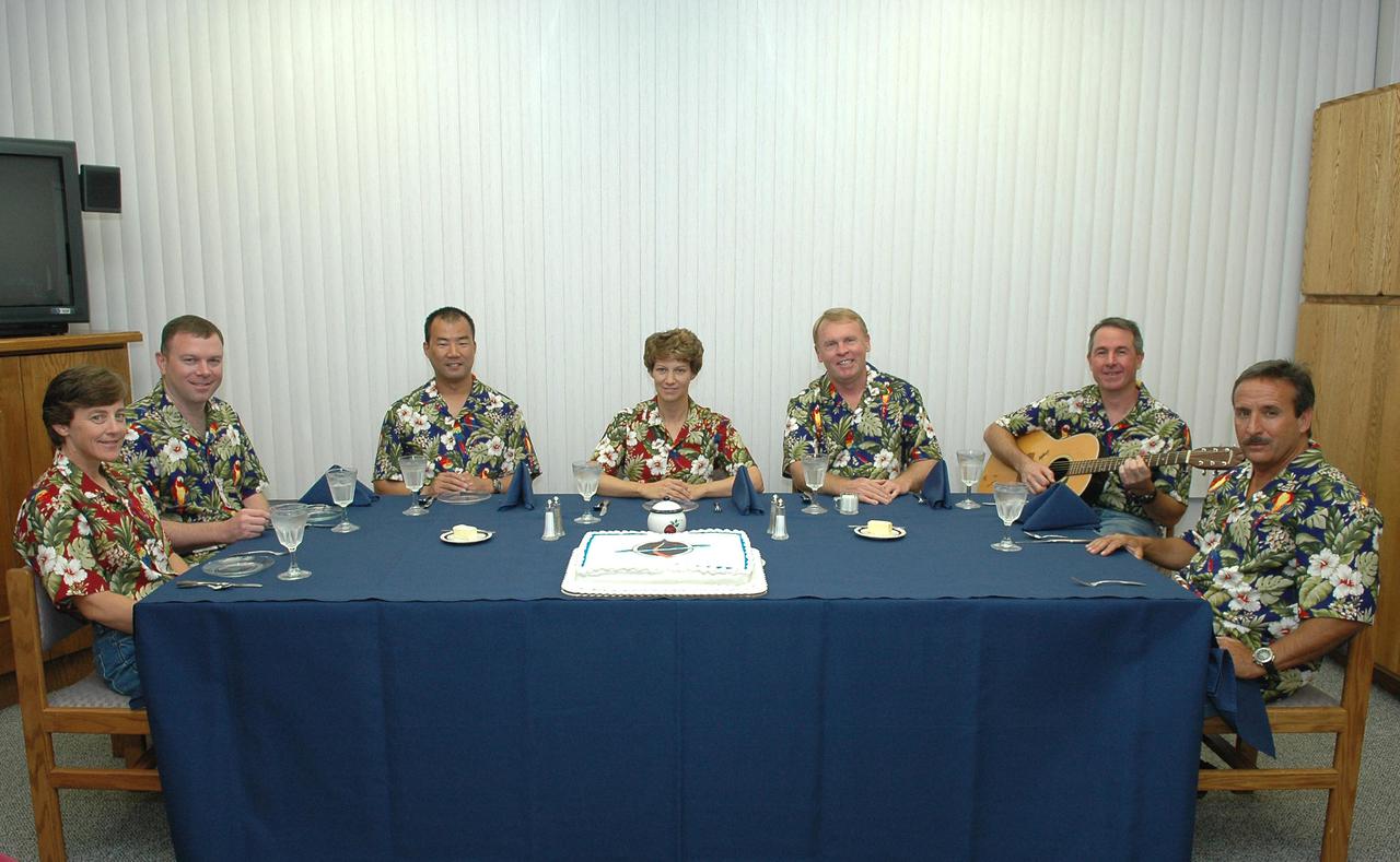 KENNEDY SPACE CENTER, FLA. - Wearing the traditional Hawaiian shirts, the STS-114 crew gathers after breakfast for the traditional cake before suiting up for launch.  Seated left to right are Mission Specialist Wendy Lawrence, Pilot James Kelly, Mission Specialist Soichi Noguchi, Mission Commander Eileen Collins and Mission Specialists Andrew Thomas, Stephen Robinson and Charles Camarda. Noguchi represents the Japan Aerospace Exploration Agency (JAXA).  The crew is scheduled to lift off aboard Space Shuttle Discovery on this historic Return to Flight mission to the International Space Station at 10:39 a.m. EDT today from Launch Pad 39B.  It is the 114th Space Shuttle flight and the 31st for Discovery.  The 12-day mission is expected to end with touchdown at the Shuttle Landing Facility on Aug. 7.