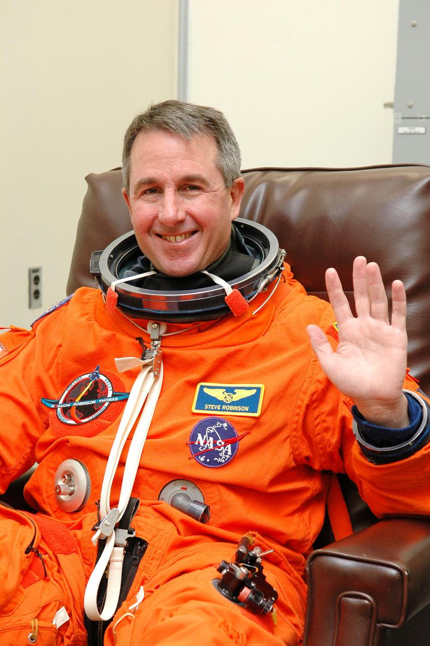 KENNEDY SPACE CENTER, FLA. -  In the Operations and Checkout Building at NASA Kennedy Space Center, STS-114 Mission Specialist Stephen Robinson dons his launch and entry suit before heading to the launch pad.  Robinson is making his third space flight on the historic Return to Flight mission STS-114 to the International Space Station.  On its second attempt for launch, Discovery is scheduled to lift off at 10:39 a.m. EDT today from Launch Pad 39B.  It is the 114th Space Shuttle flight and the 31st for Discovery.  The 12-day mission is expected to end with touchdown at the Shuttle Landing Facility on Aug. 7.