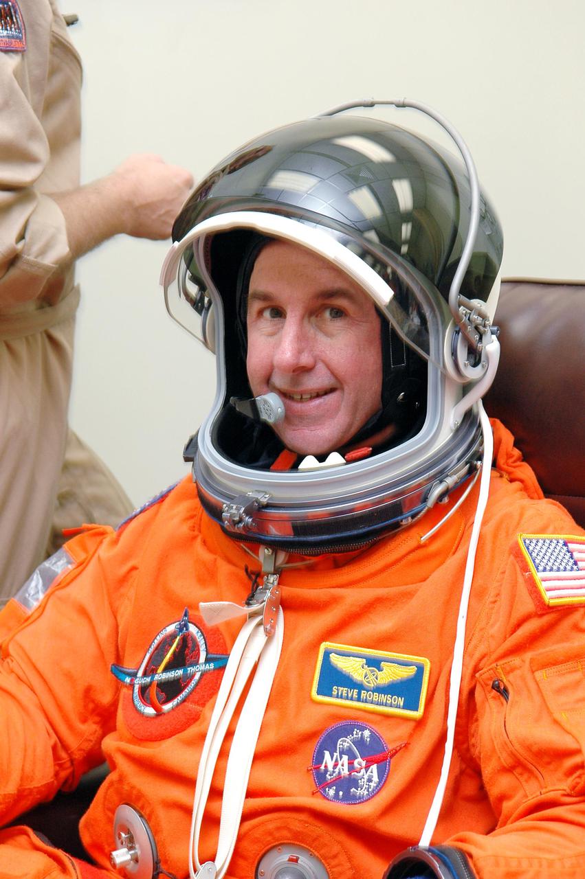 KENNEDY SPACE CENTER, FLA. -   In the Operations and Checkout Building at NASA Kennedy Space Center, STS-114 Mission Specialist Stephen Robinson is fitted with the helmet for his launch and entry suit before heading to the launch pad. Robinson is making his third space flight on the historic Return to Flight mission STS-114 to the International Space Station.  On its second attempt for launch, Discovery is scheduled to lift off at 10:39 a.m. EDT today from Launch Pad 39B.  It is the 114th Space Shuttle flight and the 31st for Discovery.  The 12-day mission is expected to end with touchdown at the Shuttle Landing Facility on Aug. 7.