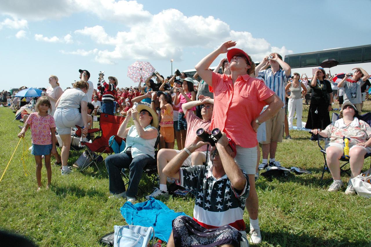 KENNEDY SPACE CENTER, FLA. - Spectators fill the grounds near NASA Kennedy Space Center to witness the launch of Space Shuttle Discovery on Return to Flight mission STS-114. They were among thousands of spectators attending the historic return of the Space Shuttle to space. It is the 114th Space Shuttle flight and the 31st for Discovery. The 12-day mission is expected to end with touchdown at the Shuttle Landing Facility on Aug. 7. On this mission to the International Space Station the crew will perform inspections on-orbit for the first time of all of the Reinforced Carbon-Carbon (RCC) panels on the leading edge of the wings and the Thermal Protection System tiles using the new Canadian-built Orbiter Boom Sensor System and the data from 176 impact and temperature sensors. Mission Specialists will also practice repair techniques on RCC and tile samples during a spacewalk in the payload bay. During two additional spacewalks, the crew will install the External Stowage Platform-2, equipped with spare part assemblies, and a replacement Control Moment Gyroscope contained in the Lightweight Multi-Purpose Experiment Support Structure.