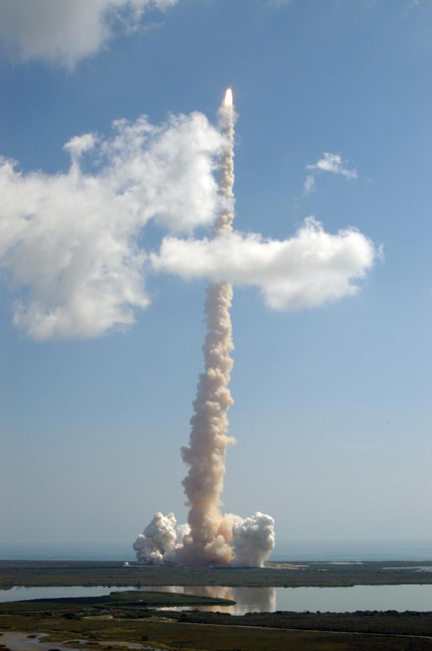 KENNEDY SPACE CENTER, FLA. -   Looking like a roman candle reaching through a cloud over Launch Pad 39B at NASA Kennedy Space Center, Space Shuttle Discovery roars into the cloud-dotted blue sky after liftoff at 10:39 a.m. EDT on the historic Return to Flight mission STS-114.   It is the 114th Space Shuttle flight and the 31st for Discovery.  The 12-day mission is expected to end with touchdown at the Shuttle Landing Facility on Aug. 7.  On this mission to the International Space Station the crew will perform inspections on-orbit for the first time of all of the Reinforced Carbon-Carbon (RCC) panels on the leading edge of the wings and the Thermal Protection System tiles using the new Canadian-built Orbiter Boom Sensor System and the data from 176 impact and temperature sensors. Mission Specialists will also practice repair techniques on RCC and tile samples during a spacewalk in the payload bay.  During two additional spacewalks, the crew will install the External Stowage Platform-2, equipped with spare part assemblies, and a replacement Control Moment Gyroscope contained in the Lightweight Multi-Purpose Experiment Support Structure.