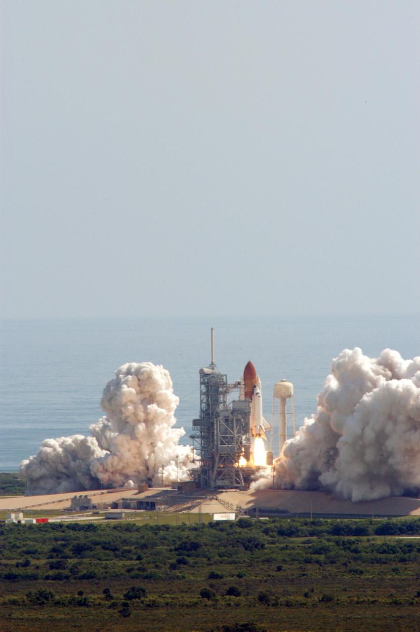 KENNEDY SPACE CENTER, FLA. - Looking like discarded piles of foam or cotton, billows of smoke and steam surround Launch Pad 39B as Space Shuttle Discovery roars toward space. Liftoff occurred at 10:39 a.m. EDT on the historic Return to Flight mission STS-114. It is the 114th Space Shuttle flight and the 31st for Discovery. The 12-day mission is expected to end with touchdown at the Shuttle Landing Facility on Aug. 7. On this mission to the International Space Station the crew will perform inspections on-orbit for the first time of all of the Reinforced Carbon-Carbon (RCC) panels on the leading edge of the wings and the Thermal Protection System tiles using the new Canadian-built Orbiter Boom Sensor System and the data from 176 impact and temperature sensors. Mission Specialists will also practice repair techniques on RCC and tile samples during a spacewalk in the payload bay. During two additional spacewalks, the crew will install the External Stowage Platform-2, equipped with spare part assemblies, and a replacement Control Moment Gyroscope contained in the Lightweight Multi-Purpose Experiment Support Structure.