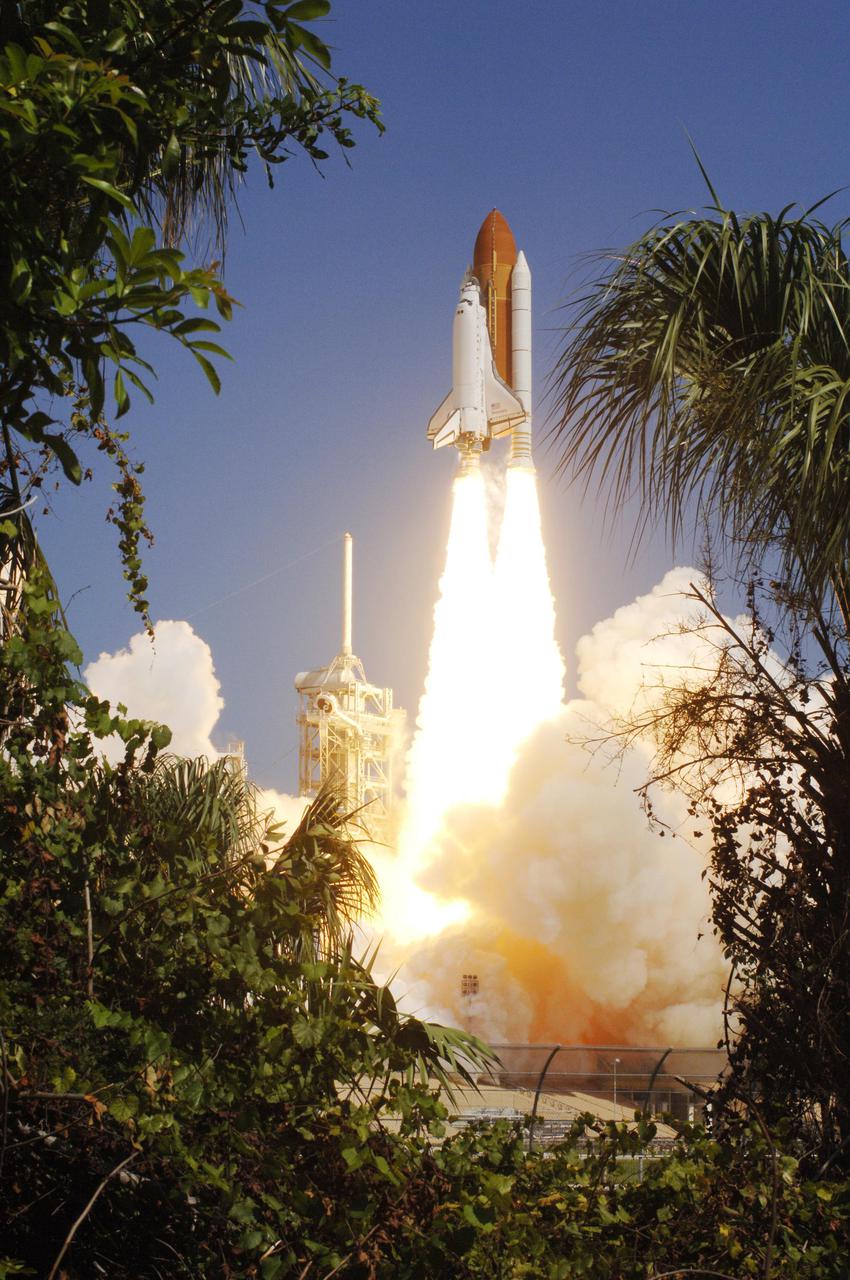 KENNEDY SPACE CENTER, FLA. -  Framed by Florida greenery, Space Shuttle Discovery lifts off Launch Pad 39B at 10:39 a.m. EDT on the historic Return to Flight mission STS-114.  It is the 114th Space Shuttle flight and the 31st for Discovery.  The 12-day mission is expected to end with touchdown at the Shuttle Landing Facility on Aug. 7.  On this mission to the International Space Station the crew will perform inspections on-orbit for the first time of all of the Reinforced Carbon-Carbon (RCC) panels on the leading edge of the wings and the Thermal Protection System tiles using the new Canadian-built Orbiter Boom Sensor System and the data from 176 impact and temperature sensors. Mission Specialists will also practice repair techniques on RCC and tile samples during a spacewalk in the payload bay.  During two additional spacewalks, the crew will install the External Stowage Platform-2, equipped with spare part assemblies, and a replacement Control Moment Gyroscope contained in the Lightweight Multi-Purpose Experiment Support Structure.