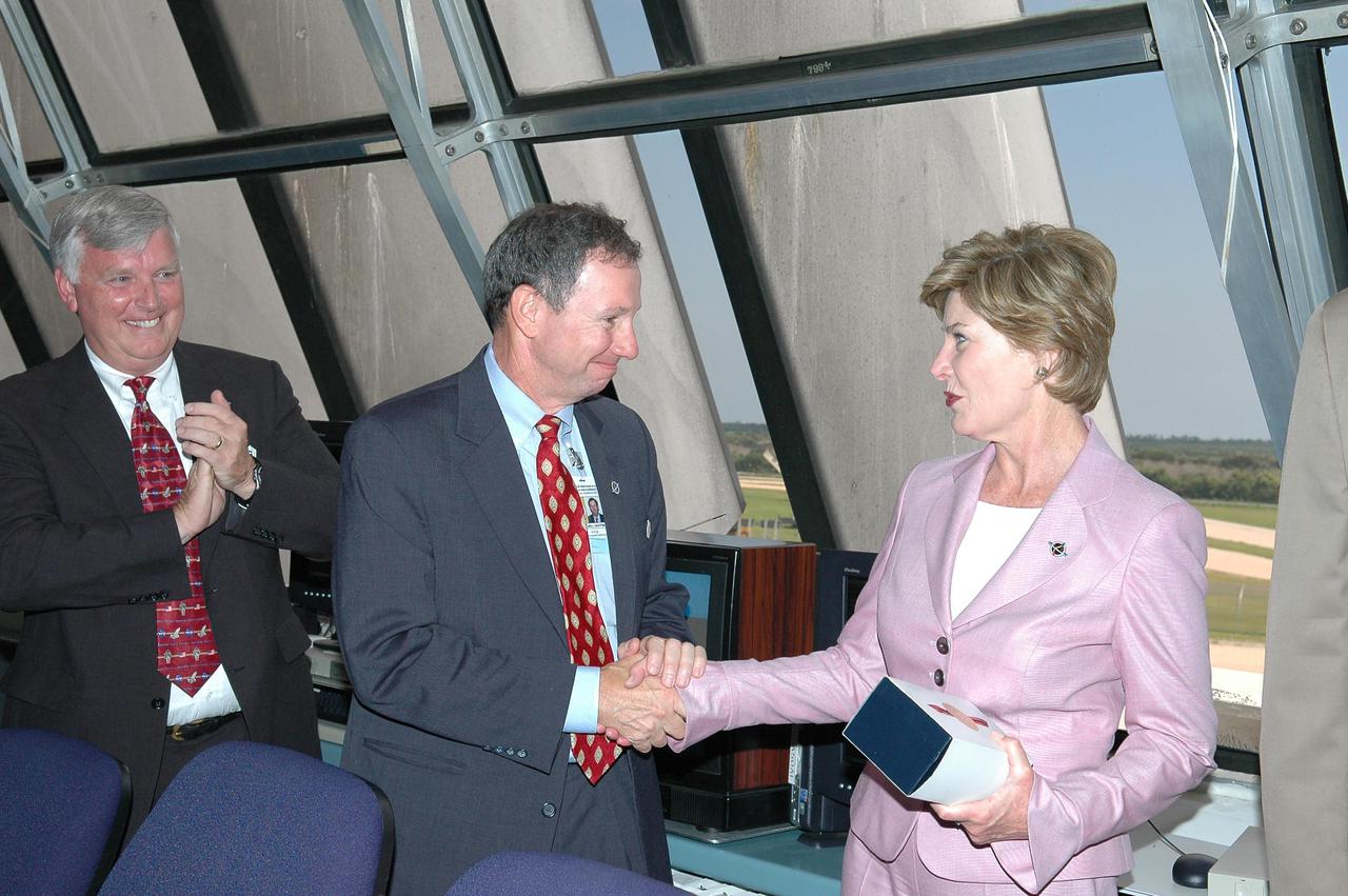 KENNEDY SPACE CENTER, FLA. - In the Launch Control Center at NASA Kennedy Space Center, First Lady Laura Bush thanks NASA Administrator for his hospitality.  At far left is Center Director Jim Kennedy.  Mrs. Bush witnessed the historic launch of Space Shuttle Discovery on Return to Flight mission STS-114.  She is only the third First Lady to witness a Space Shuttle launch at KSC.On this mission to the International Space Station the crew will perform inspections on-orbit for the first time of all of the Reinforced Carbon-Carbon (RCC) panels on the leading edge of the wings and the Thermal Protection System tiles using the new Canadian-built Orbiter Boom Sensor System and the data from 176 impact and temperature sensors. Mission Specialists will also practice repair techniques on RCC and tile samples during a spacewalk in the payload bay.  During two additional spacewalks, the crew will install the External Stowage Platform-2, equipped with spare part assemblies, and a replacement Control Moment Gyroscope contained in the Lightweight Multi-Purpose Experiment Support Structure. The 12-day mission is expected to end with touchdown at the Shuttle Landing Facility on Aug. 7.
