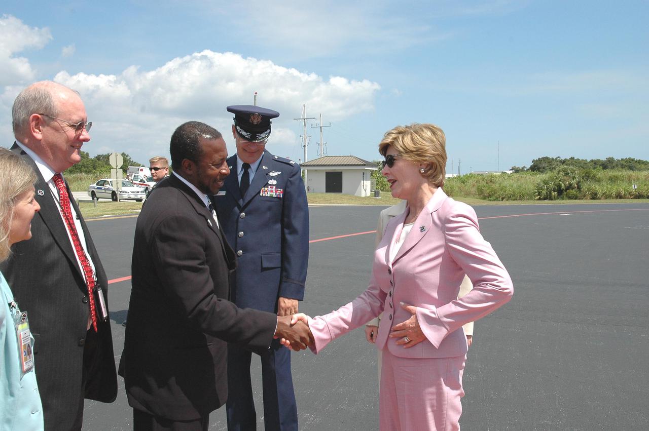 KENNEDY SPACE CENTER, FLA. - At the Skid Strip on Cape Canaveral Air Force Station, First Lady Laura Bush says farewell to KSC Deputy Director Woodrow Whitlow Jr. At left is Associate Director Jim Hattaway. Mrs. Bush witnessed the historic launch of Space Shuttle Discovery on Return to Flight mission STS-114. She is only the third First Lady to witness a Space Shuttle launch at KSC. On this mission to the International Space Station the crew will perform inspections on-orbit for the first time of all of the Reinforced Carbon-Carbon (RCC) panels on the leading edge of the wings and the Thermal Protection System tiles using the new Canadian-built Orbiter Boom Sensor System and the data from 176 impact and temperature sensors. Mission Specialists will also practice repair techniques on RCC and tile samples during a spacewalk in the payload bay. During two additional spacewalks, the crew will install the External Stowage Platform-2, equipped with spare part assemblies, and a replacement Control Moment Gyroscope contained in the Lightweight Multi-Purpose Experiment Support Structure. The 12-day mission is expected to end with touchdown at the Shuttle Landing Facility on Aug. 7.