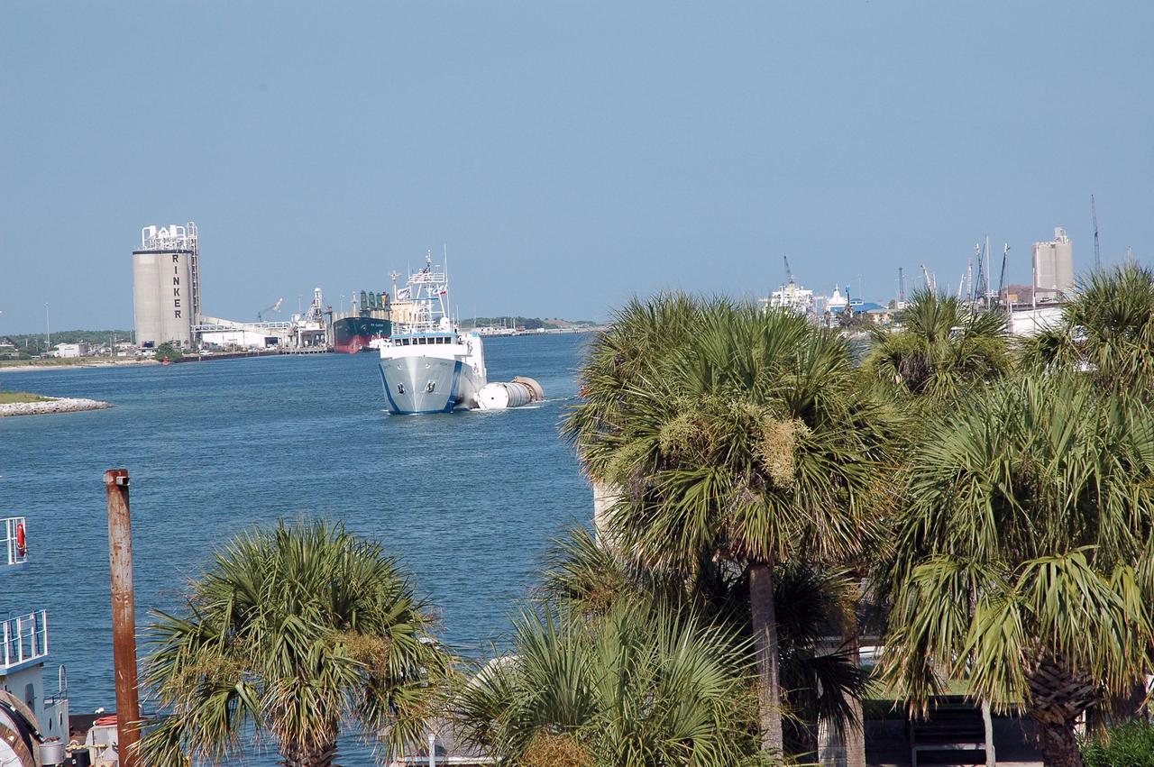 KENNEDY SPACE CENTER, FLA. - The solid rocket booster recovery ship Freedom Star enters Port Canaveral with a spent solid rocket booster (SRB) from the STS-114 launch on July 26 in tow.  The SRBs are the largest solid propellant motors ever flown and the first designed for reuse. After a Shuttle is launched, the SRBs are jettisoned at two minutes, seven seconds into the flight. At six minutes and 44 seconds after liftoff, the spent SRBs, weighing about 165,000 lb., have slowed their descent speed to about 62 mph and splashdown takes place in a predetermined area. They are retrieved from the Atlantic Ocean by special recovery vessels and returned for refurbishment and eventual reuse on future Shuttle flights. Once at Hangar AF, the SRBs are unloaded onto a hoisting slip and mobile gantry cranes lift them onto tracked dollies where they are safed and undergo their first washing.