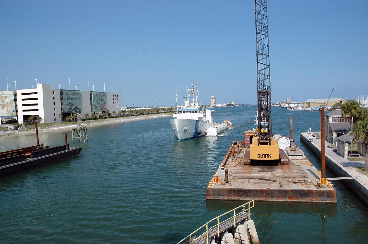 KENNEDY SPACE CENTER, FLA. - The solid rocket booster recovery ship Freedom Star makes its way through Port Canaveral with a spent solid rocket booster (SRB) from the STS-114 launch on July 26 in tow.  The SRBs are the largest solid propellant motors ever flown and the first designed for reuse. After a Shuttle is launched, the SRBs are jettisoned at two minutes, seven seconds into the flight. At six minutes and 44 seconds after liftoff, the spent SRBs, weighing about 165,000 lb., have slowed their descent speed to about 62 mph and splashdown takes place in a predetermined area. They are retrieved from the Atlantic Ocean by special recovery vessels and returned for refurbishment and eventual reuse on future Shuttle flights. Once at Hangar AF, the SRBs are unloaded onto a hoisting slip and mobile gantry cranes lift them onto tracked dollies where they are safed and undergo their first washing.