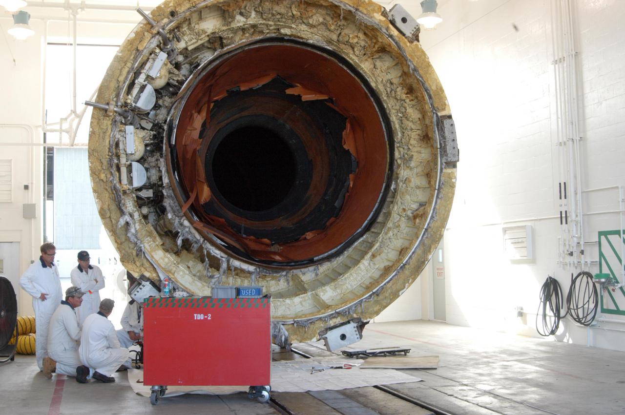 KENNEDY SPACE CENTER, FLA. - One of the spent Solid Rocket Boosters (SRBs) from the launch of Space Shuttle Discovery July 26 on Return to Flight mission STS-114 is moved into Hangar AF at Cape Canaveral Air Force Station.  The SRBs are the largest solid propellant motors ever flown and the first designed for reuse. After a Shuttle is launched, the SRBs are jettisoned at two minutes, seven seconds into the flight. At six minutes and 44 seconds after liftoff, the spent SRBs, weighing about 165,000 lb., have slowed their descent speed to about 62 mph and splashdown takes place in a predetermined area. They are retrieved from the Atlantic Ocean by special recovery vessels and returned for refurbishment and eventual reuse on future Shuttle flights. Once at Hangar AF, the SRBs are unloaded onto a hoisting slip and mobile gantry cranes lift them onto tracked dollies where they are safed and undergo their first washing.