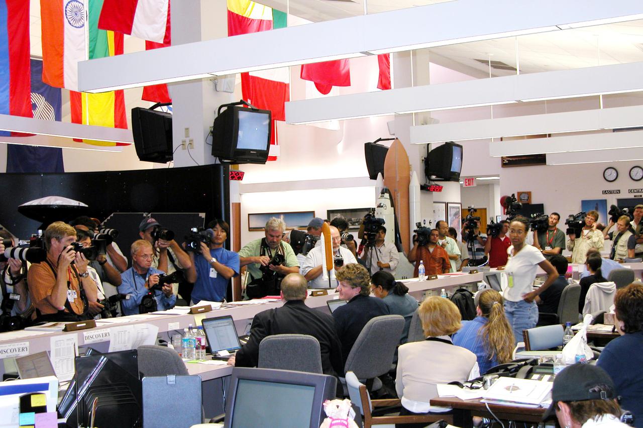 KENNEDY SPACE CENTER, FLA. - Unable to photograph or video a KSC Shuttle landing, which instead occurred at Edwards Air Force Base in California, the media focus on the workers at the NASA News Center who follow the path of Discovery on television and computers. Due to weather concerns, the landing was deferred to the alternate site. The 13-day, 21-hour Return to Flight STS-114 mission ended on Runway 22 at 8:11:22 a.m. EDT with Mission Commander Eileen Collins on the controls. Discovery spent two weeks in space, where the crew demonstrated new methods to inspect and repair the Shuttle in orbit. The crew also delivered supplies, outfitted and performed maintenance on the International Space Station. A number of these tasks were conducted during three spacewalks. Photo credit: NASA_Debbie Kiger