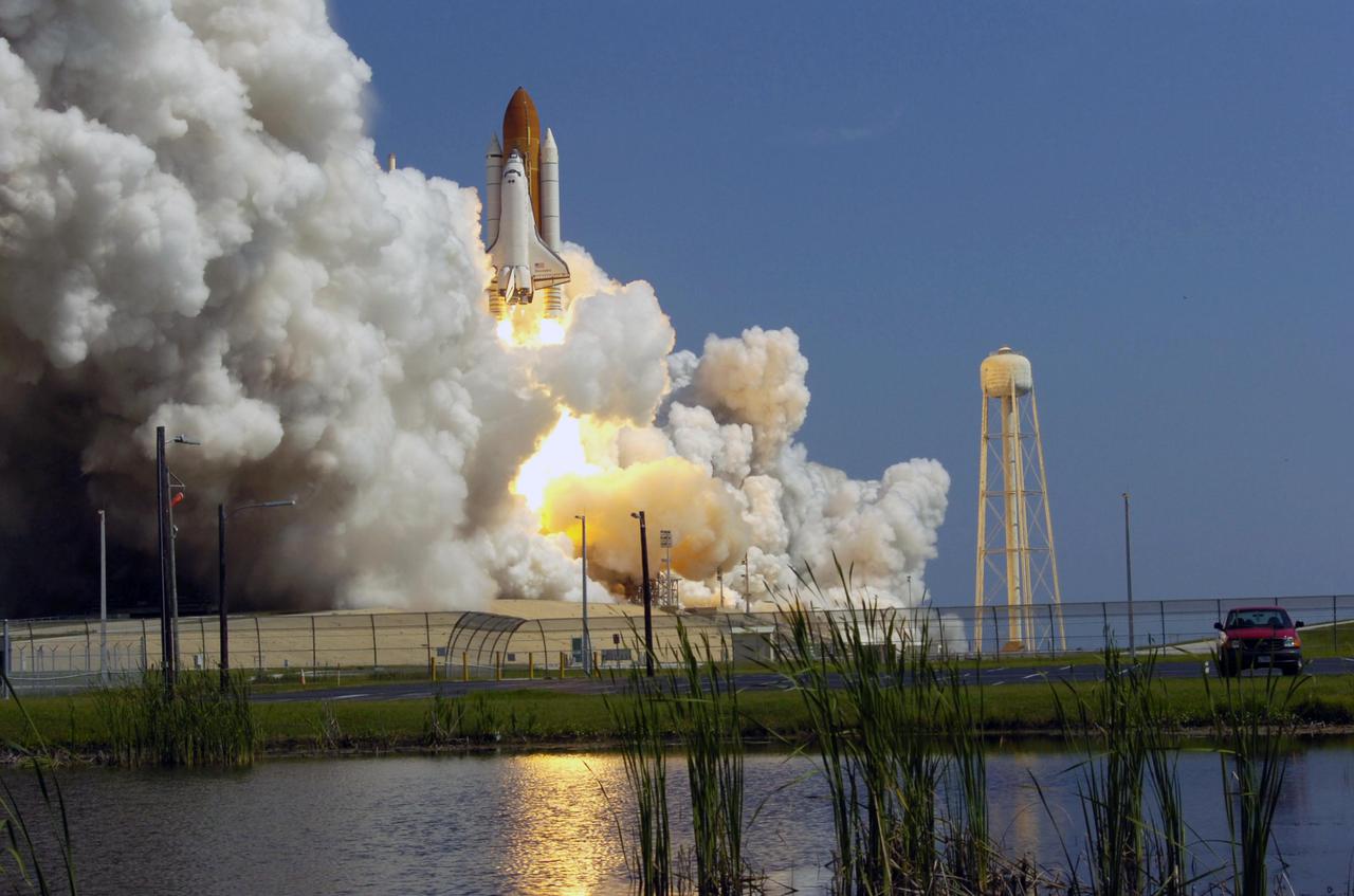 KENNEDY SPACE CENTER, FLA. -   Huge mounds of smoke and steam flow over Launch Pad 39B as Space Shuttle Discovery lifts off at 10:39 a.m. EDT on the historic Return to Flight mission STS-114.  It is the 114th flight in the Space Shuttle Program and the 31st for Discovery.  The 12-day mission is expected to end with touchdown at the Shuttle Landing Facility on Aug. 7.  On this mission to the International Space Station the crew will perform inspections on-orbit for the first time of all of the Reinforced Carbon-Carbon (RCC) panels on the leading edge of the wings and the Thermal Protection System tiles using the new Canadian-built Orbiter Boom Sensor System and the data from 176 impact and temperature sensors. Mission Specialists will also practice repair techniques on RCC and tile samples during a spacewalk in the payload bay.  During two additional spacewalks, the crew will install the External Stowage Platform-2, equipped with spare part assemblies, and a replacement Control Moment Gyroscope contained in the Lightweight Multi-Purpose Experiment Support Structure.  (Photo Credit: Scott Andrews)