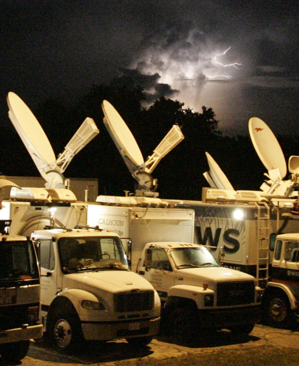 KENNEDY SPACE CENTER, FLA. - Lightning streaks across the sky above satellite trucks at NASA Kennedy Space Center’s Shuttle Landing Facility. The trucks are waiting for the early morning landing of Space Shuttle Discovery, returning from the successful Return to Flight mission STS-114. The landing was eventually deferred to Edwards Air Force Base in California due to weather concerns. The landing occurred at 8:11 a.m. EDT, guided by Mission Commander Eileen Collins. Discovery spent two weeks in space on Return to Flight mission STS-114, where the crew demonstrated new methods to inspect and repair the Shuttle in orbit. The crew also delivered supplies, outfitted and performed maintenance on the International Space Station. A number of these tasks were conducted during three spacewalks. (Photo Credit: Larry Rubenstein)