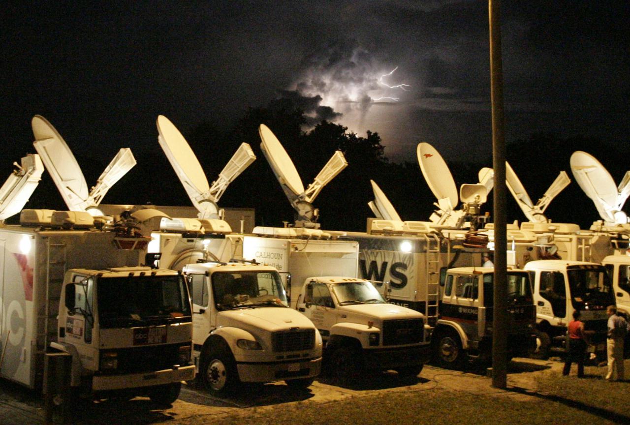 KENNEDY SPACE CENTER, FLA. - Lightning streaks across the sky above satellite trucks at NASA Kennedy Space Center’s Shuttle Landing Facility. The trucks are waiting for the early morning landing of Space Shuttle Discovery, returning from the successful Return to Flight mission STS-114. The landing was eventually deferred to Edwards Air Force Base in California due to weather concerns. The landing occurred at 8:11 a.m. EDT, guided by Mission Commander Eileen Collins. Discovery spent two weeks in space on Return to Flight mission STS-114, where the crew demonstrated new methods to inspect and repair the Shuttle in orbit. The crew also delivered supplies, outfitted and performed maintenance on the International Space Station. A number of these tasks were conducted during three spacewalks. (Photo Credit: Larry Rubenstein)